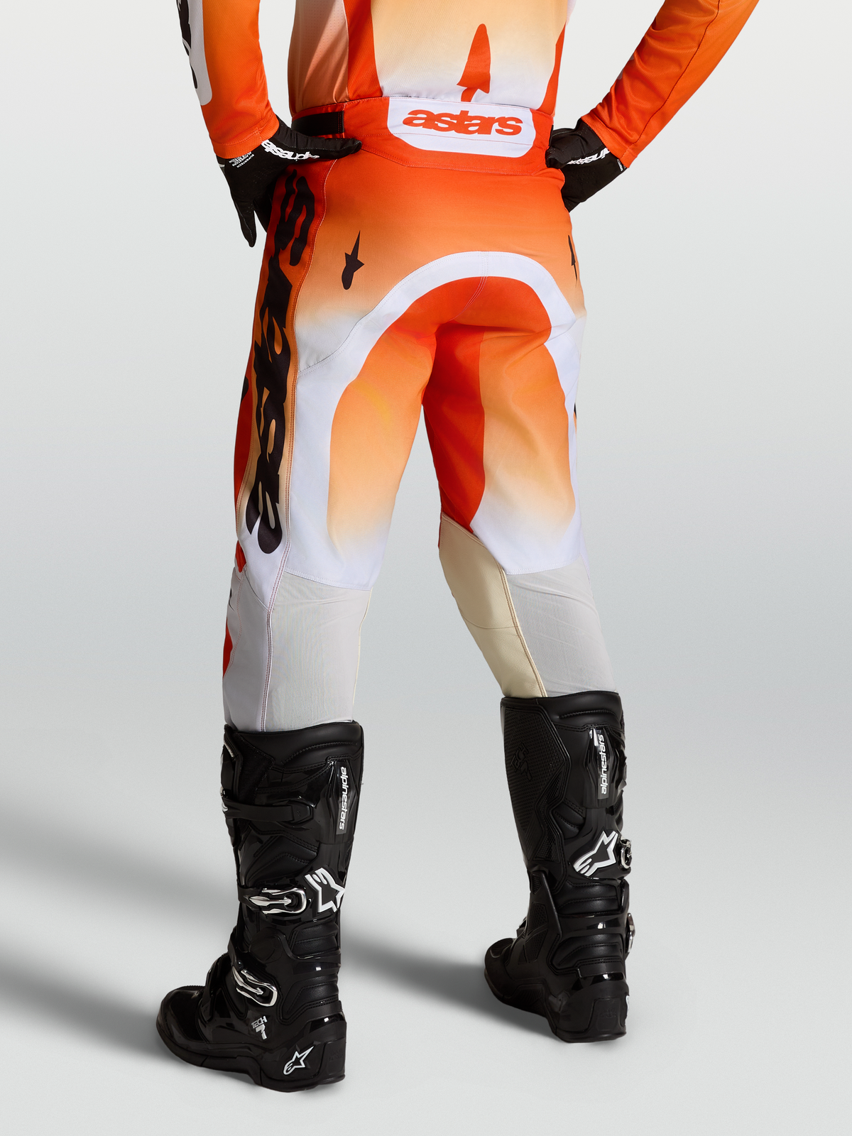 Alpinestars Racer Amber Hose, Motocross-Hose f$r Herren in Orange und Wei$ mit schwarzen Tech 7 Stiefeln, ergonomische Passform f$r Offroad-Eins$tze.