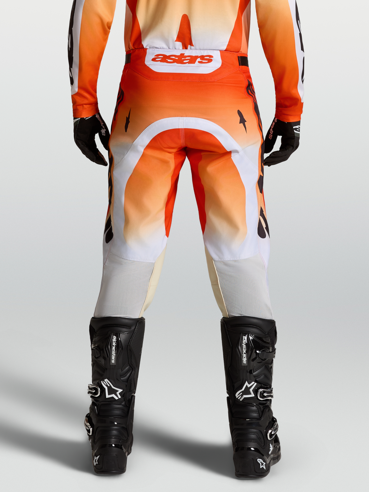 Alpinestars Racer Amber Hose, Motocross-Hose in Rot und Weiß, Rückansicht am Model mit schwarzen Stiefeln