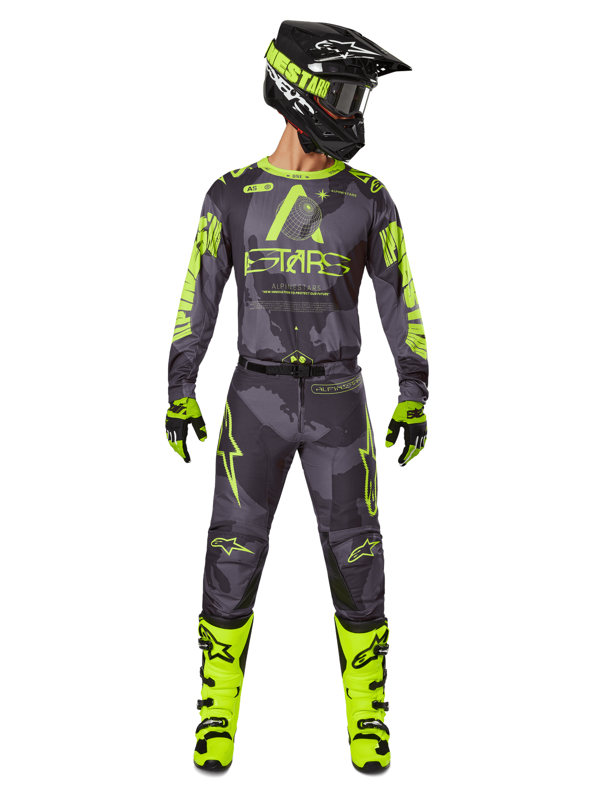 Motocross-Fahrer in kompletter Rennausrüstung, Alpinestars 2025 Racer Hollow Trikot und passende Hose in Dark Camo Yellow Fluo, mit auffälligen neongelben Grafiken auf dunkelgrauem Camouflage-Hintergrund, kombiniert mit passenden Handschuhen, leuchtend neongelben Stiefeln und einem schwarzen Helm.