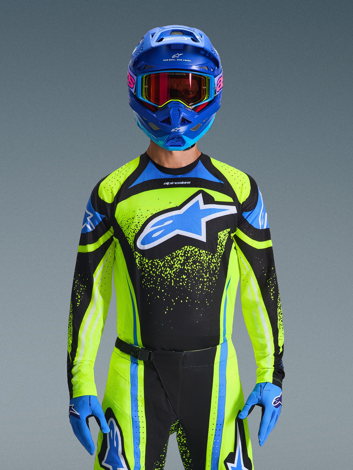 Motocross-Fahrer im Alpinestars 2026 Techstar Nomur Trikot in Dark Navy und Yellow Fluo mit blauen Akzenten, großes blaues Logo auf der Brust, passender blauer Helm und Goggles, abgestimmte Rennausrüstung für Offroad-Wettkämpfe