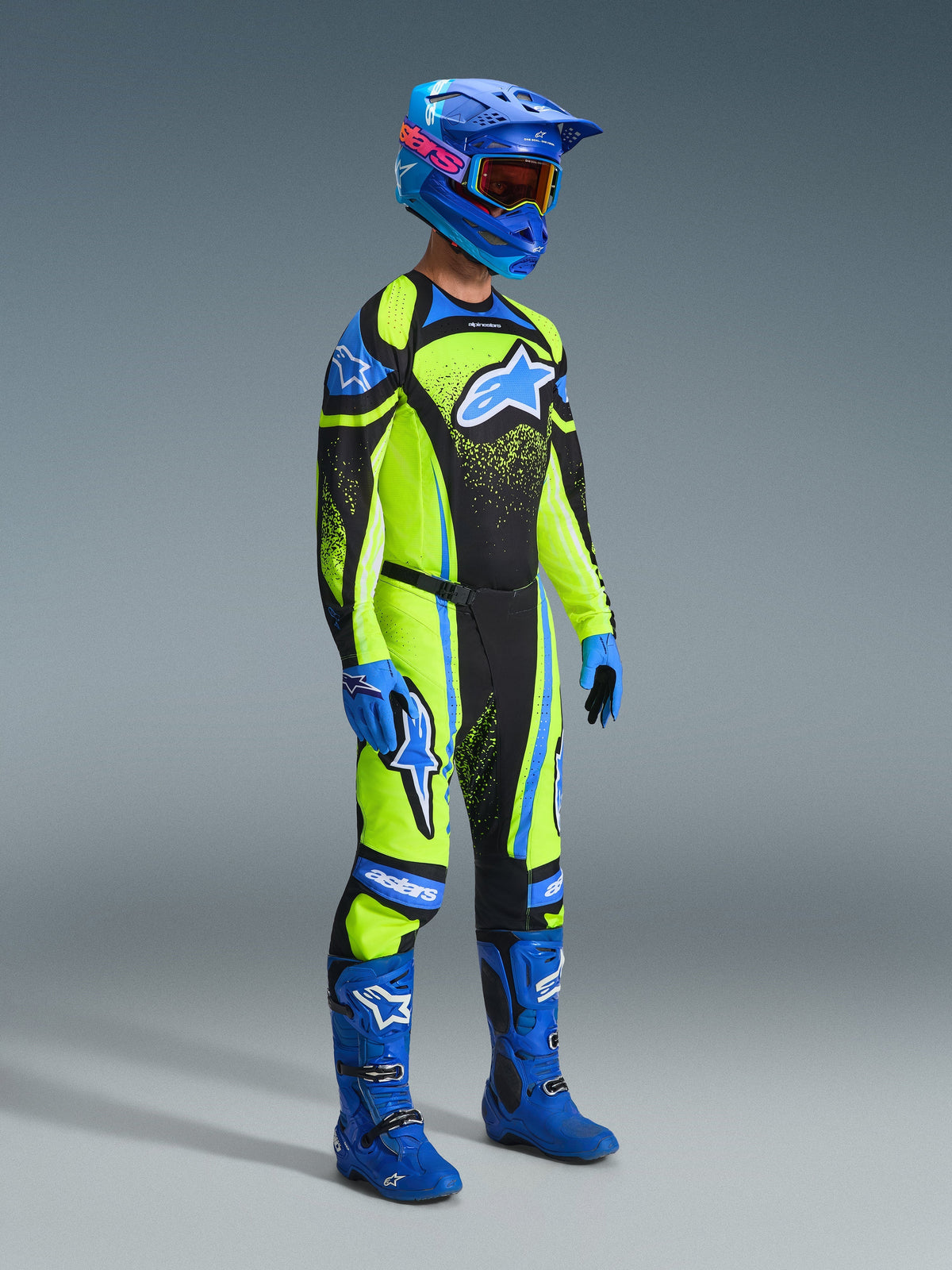 Motocross-Fahrer in kompletter Rennausrüstung, 2026 Techstar Nomur Trikot in Dark Navy und Yellow Fluo, passende Hose, blauer Helm mit Brille, blaue Stiefel und Handschuhe, abgestimmtes Outfit für Offroad-Rennen