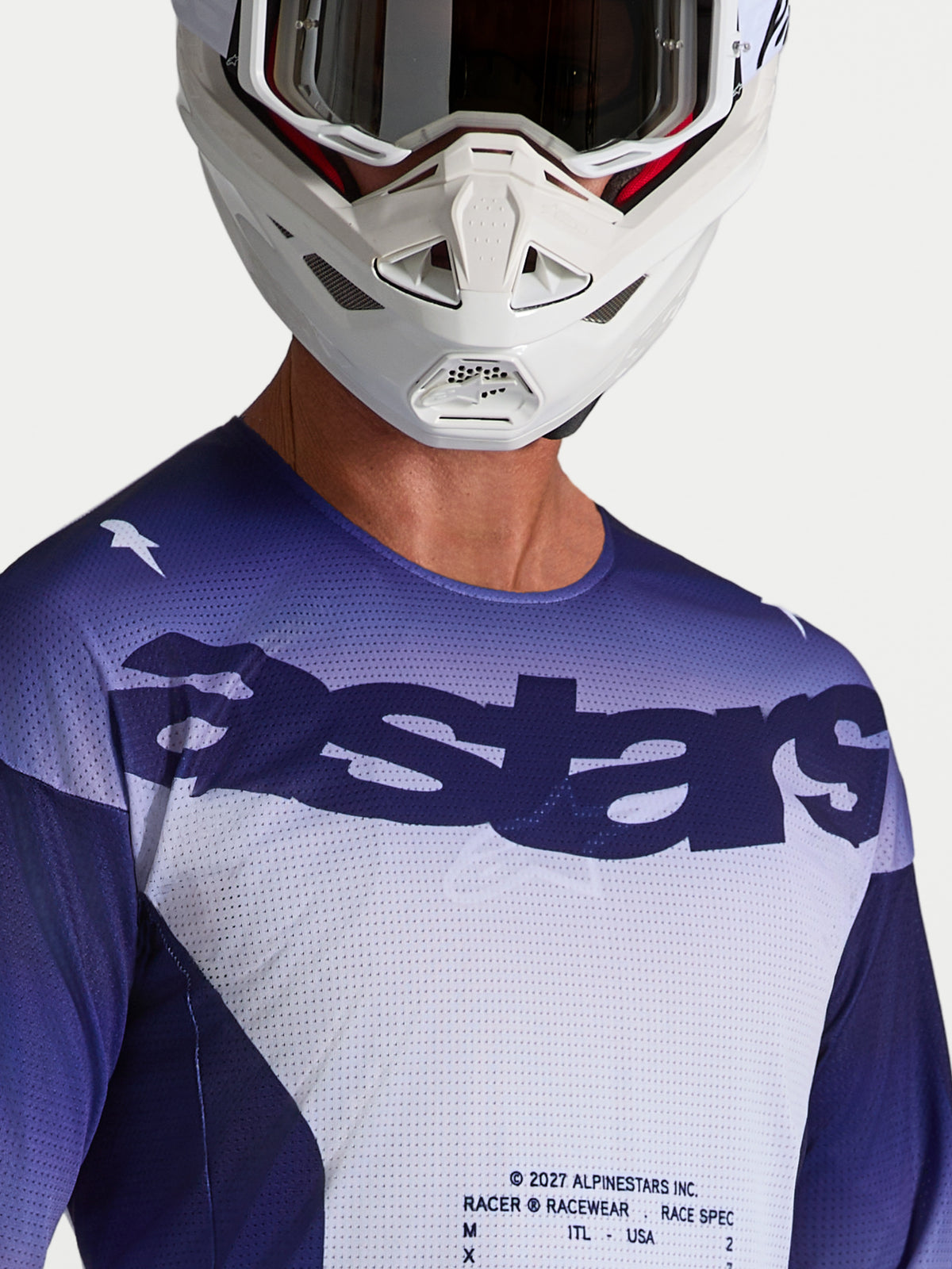 Alpinestars Racer Air Amber Trikot in Blau und Weiß, Motocross-Mesh-Jersey mit Astars-Logo am Model mit Helm.