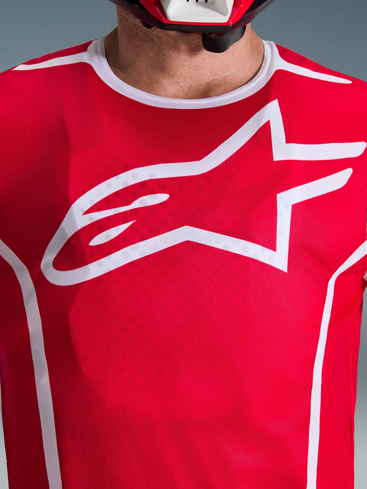 Alpinestars 2026 Fluid Apex Jersey, Red and White, close-up view of chest with large white Astars logo, white sport collar, and moisture-wicking fabric for motocross performance