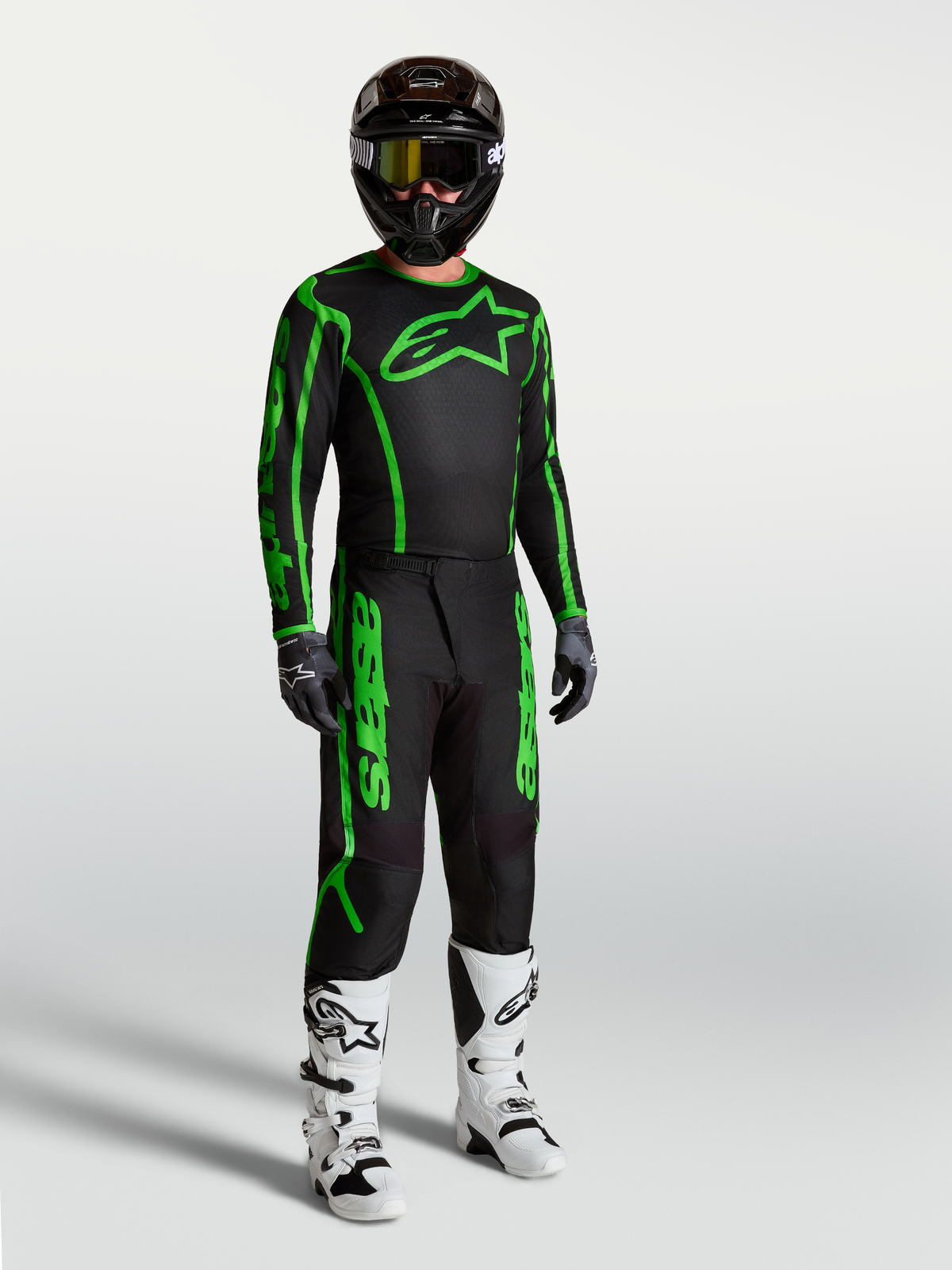 Alpinestars Fluid Apex V2 Trikot, Herren-Motocross-Trikot in Schwarz und Neongrün, am Model mit passender Hose und Stiefeln.