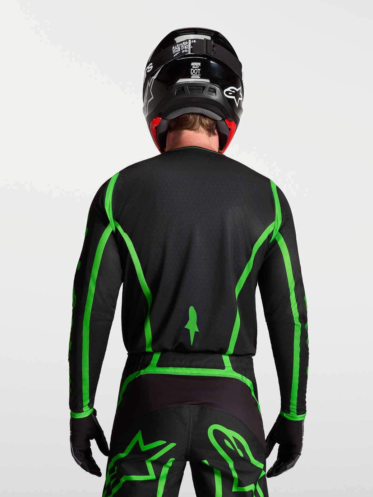 Alpinestars Fluid Apex V2 Trikot für Motocross, Schwarz und fluoreszierendes Grün, Rückansicht mit verlängertem Rückenteil.