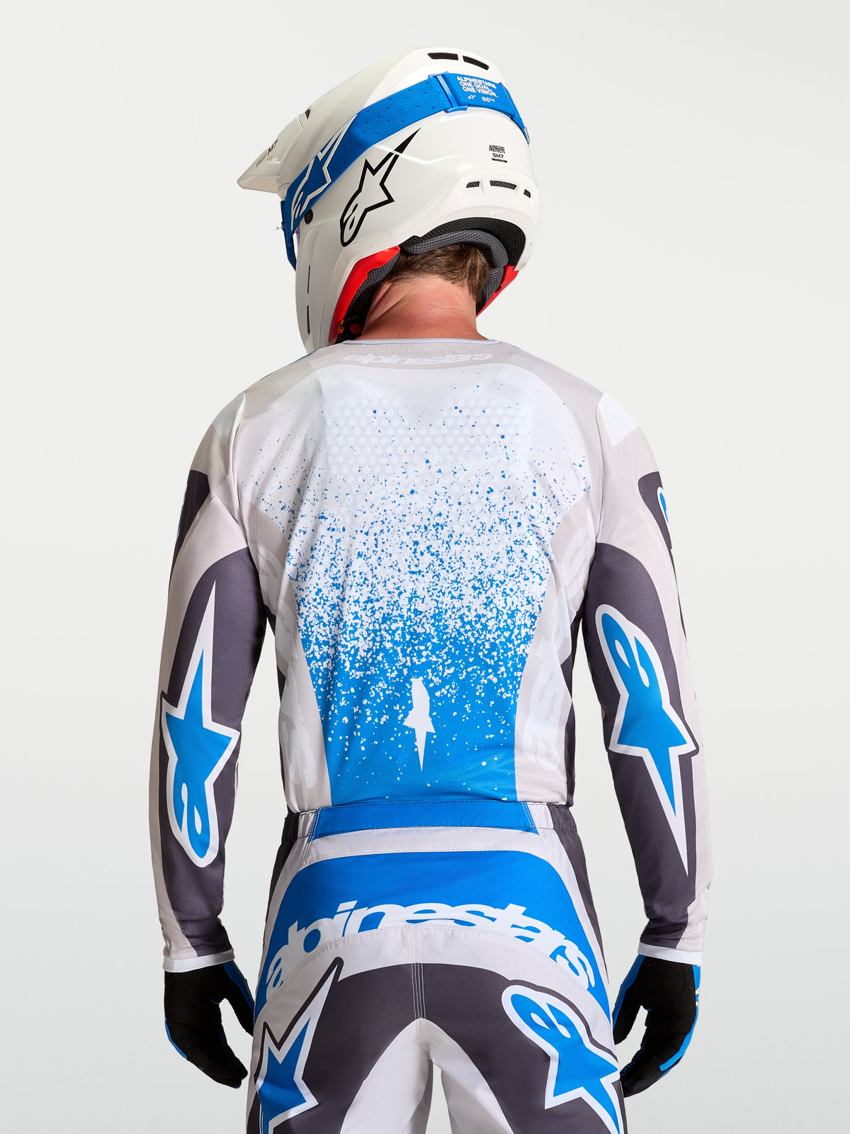 Alpinestars Fluid Drag Trikot, atmungsaktives Motocross-Trikot für Herren in Grau und Blau, Rückansicht mit verlängerter Rückenpartie für verbesserte Abdeckung, leichtes feuchtigkeitsableitendes Material für Motocross und Offroad.