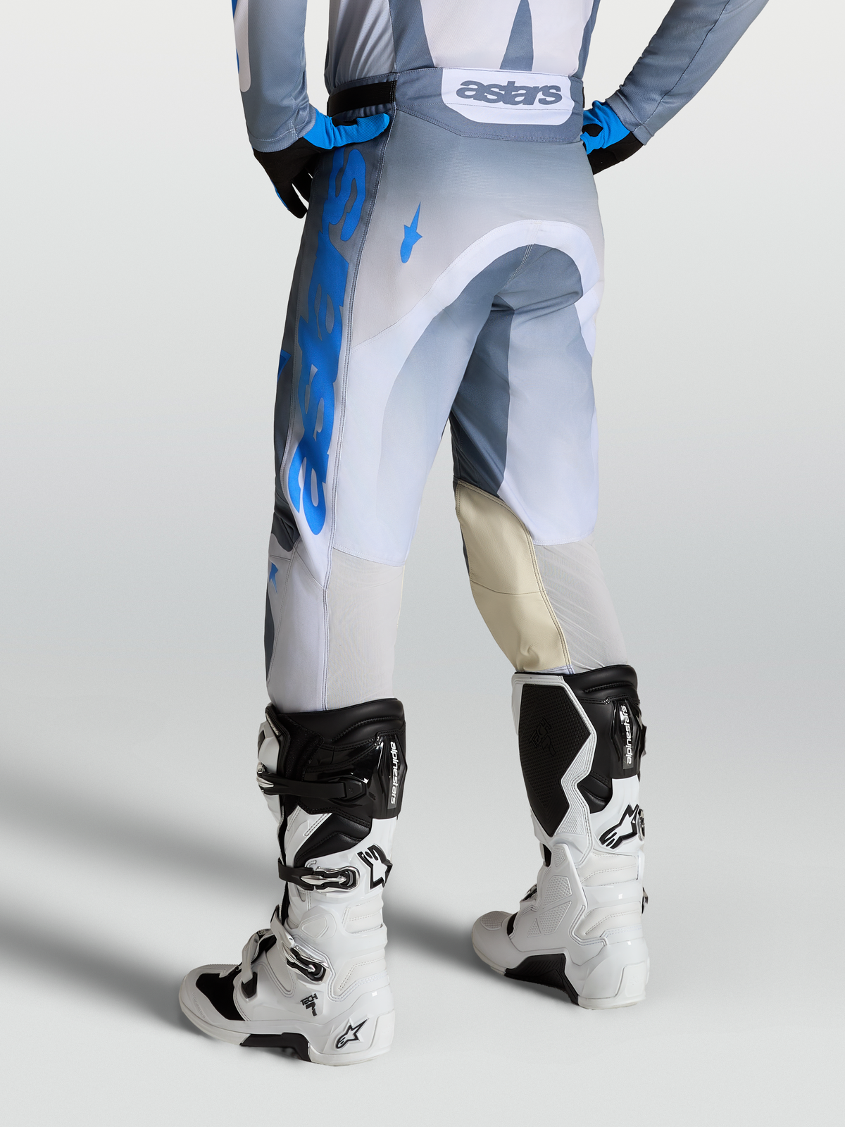 Alpinestars Racer Amber Hose, Motocross-Hose für Herren in Aschgrau und Blau, mit Leder-Knieeinsätzen, Rückansicht an einem Model mit Tech 7 Stiefeln.