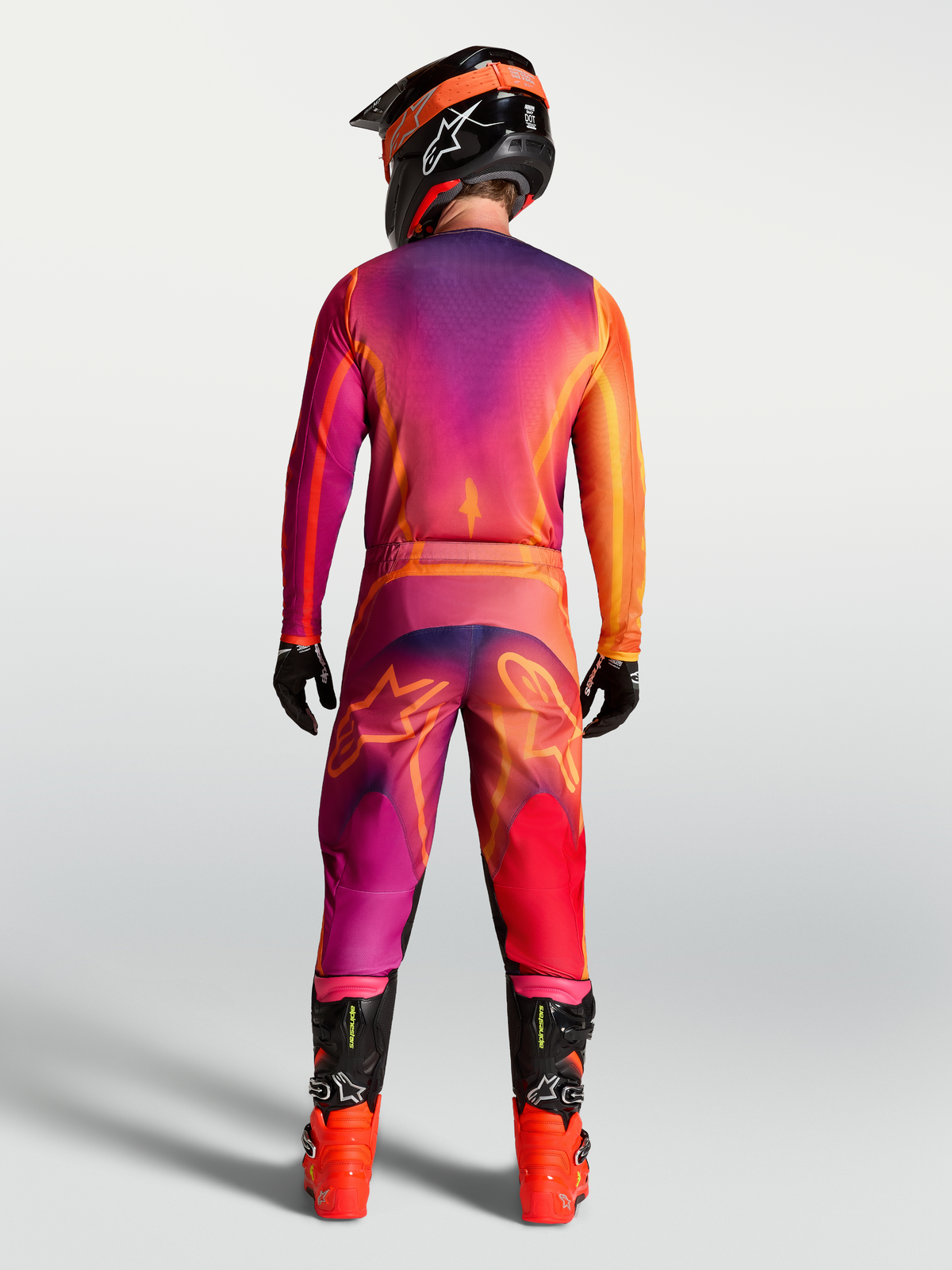Alpinestars Fluid Kepler Pants in Dark Purple and Orange, back view on-model with matching jersey and boots, sport-fit motocross pants with reinforced polyfabric for off-road performance.
