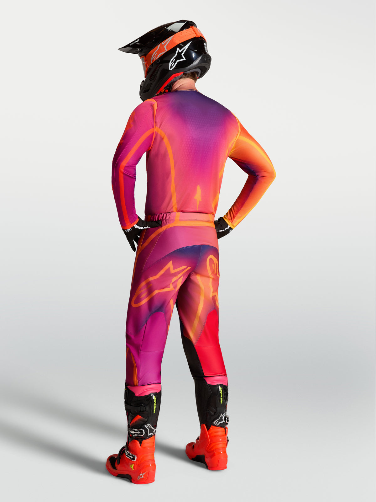 Alpinestars Fluid Kepler Trikot in Lila und Orange, Performance-Motocross-Ausrüstung in der Rückansicht eines Fahrers.