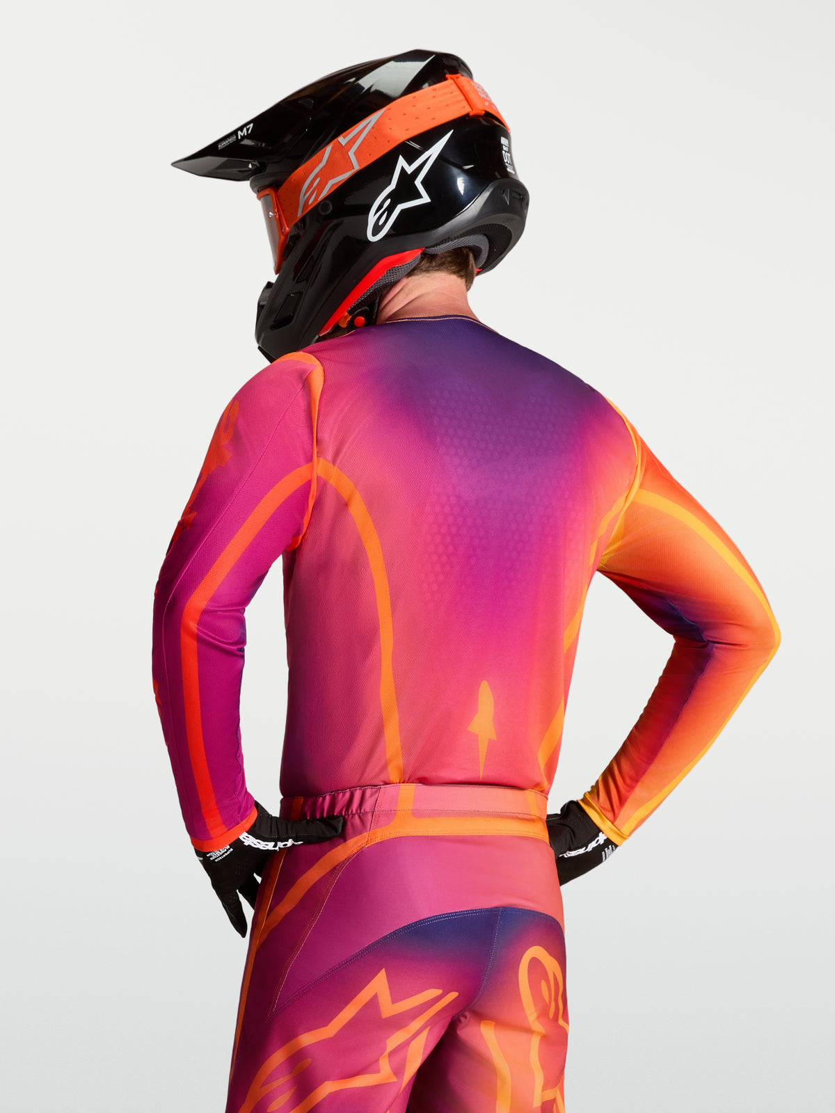 Alpinestars Fluid Kepler Trikot, Motocross-Trikot für Herren, Lila und Orange, Rückansicht auf einem Model zeigt die ergonomische Passform und das feuchtigkeitsableitende Material für Motocross und Geländefahrt.