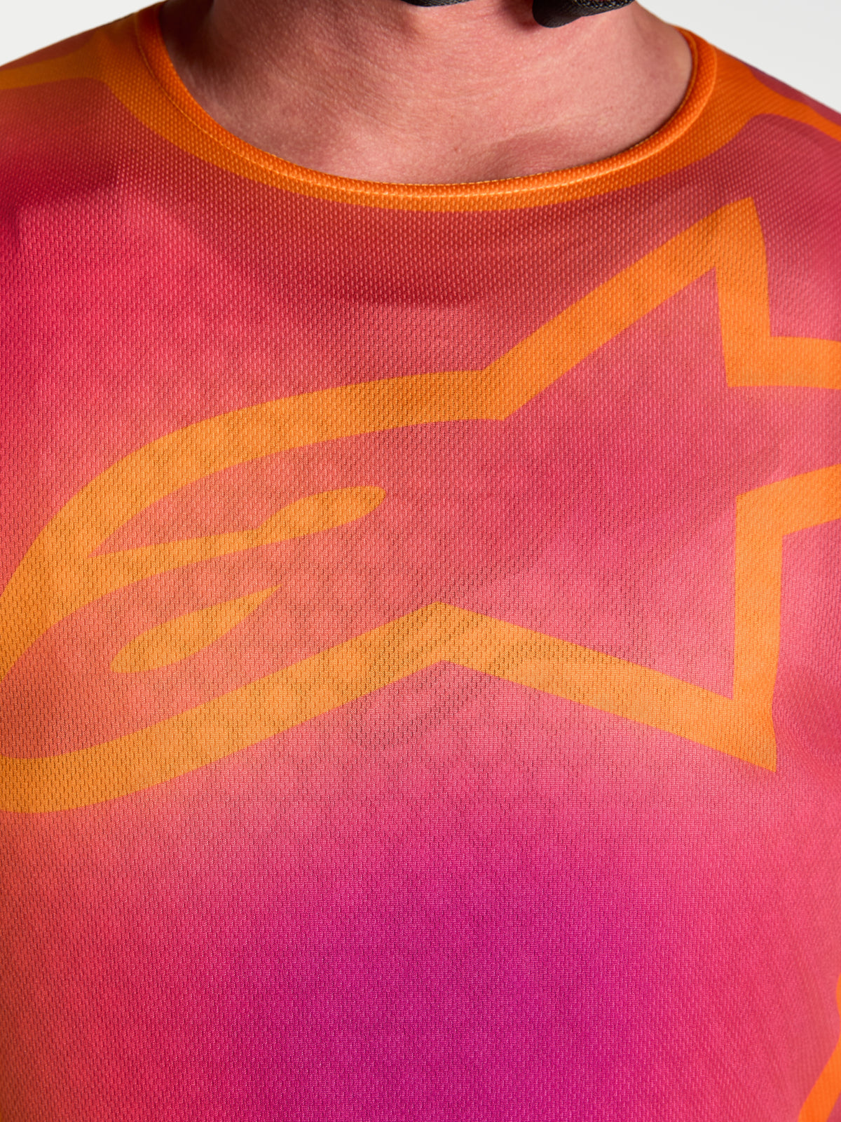 Alpinestars Fluid Kepler Trikot, Motocross-Jersey, Lila und Orange, Nahaufnahme des Brustdesigns mit A-star Logo.