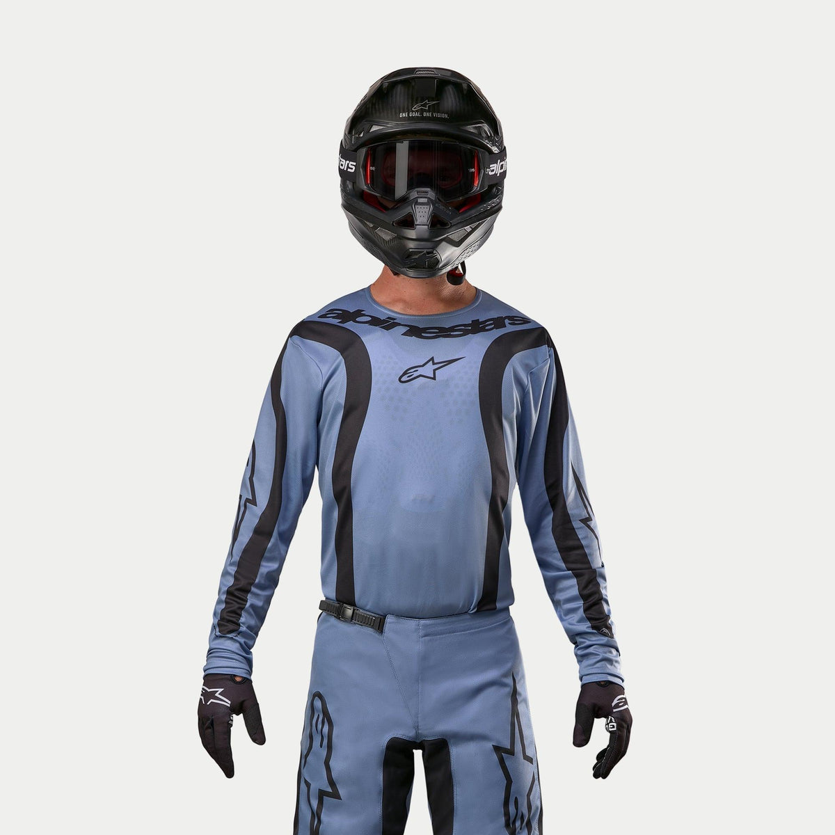Alpinestars 2024 Fluid Lurv Trikot, Motocross-Trikot, Hellblau und Schwarz, getragen von einem Fahrer mit passender Hose, schwarzem Helm mit roter Brille und schwarzen Handschuhen, koordiniertes Outfit für Offroad-Rennen