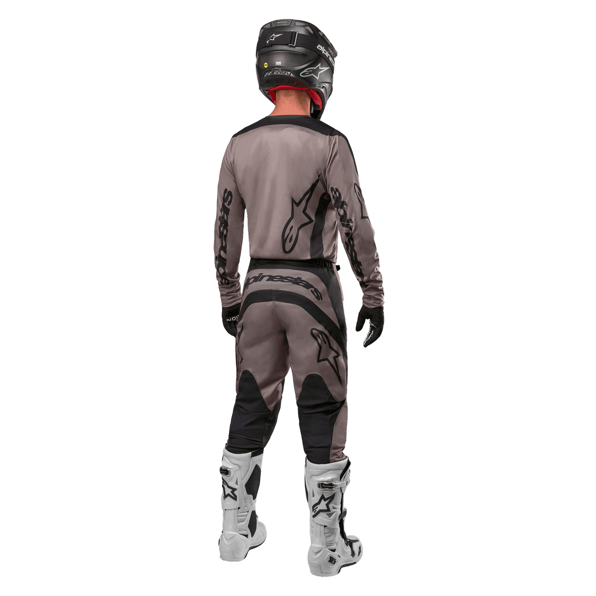 Alpinestars 2024 Fluid Lurv Jersey, Motocross Jersey, Mud Black, rear view of motocross rider wearing matching racing gear, black helmet, and white boots, featuring bold black Alpinestars logos and an athletic fit for off-road performance.