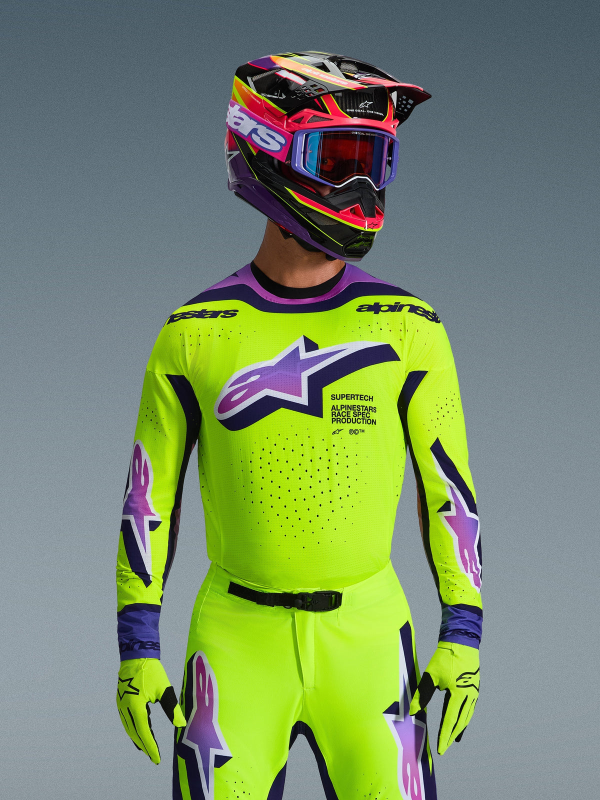 Alpinestars 2026 Supertech Vista Jersey, Motocross-Trikot, leuchtendes Neongelb mit lila und schwarzen Akzenten, getragen mit passendem Motocross-Helm, Brille und Handschuhen, athletische Profi-Passform für den Offroad-Rennsport
