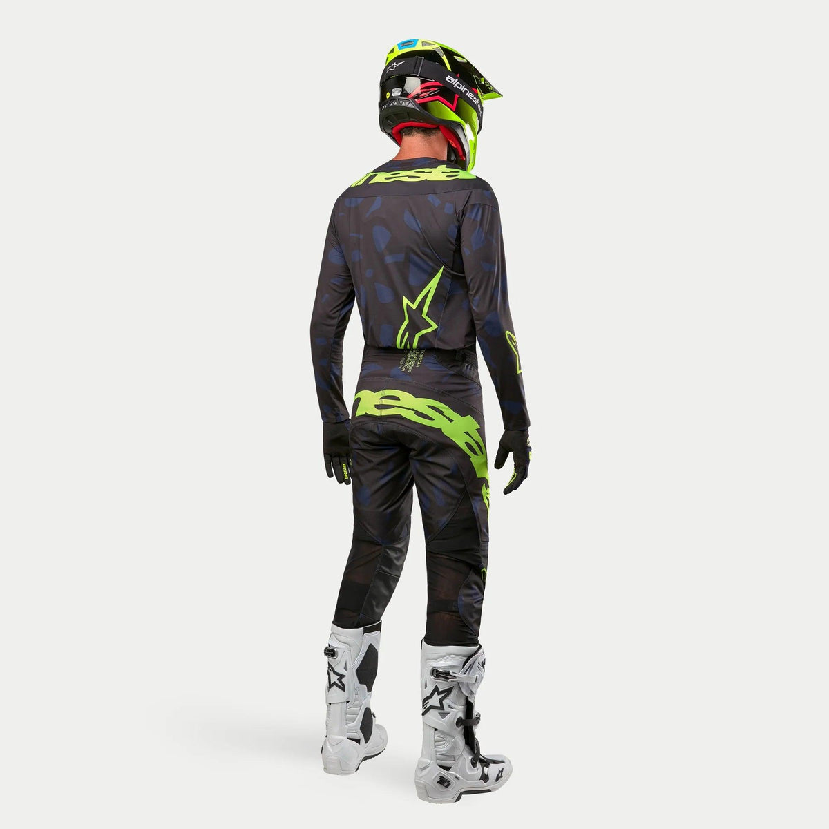 Alpinestars 2024 Techstar Rantera Trikot, Motocross-Trikot, Schwarz, Navy und Neon-Gelb, kombiniert mit passender Hose, weiß-schwarzen Stiefeln und einem neon-gelben Helm, Rückansicht in kompletter Offroad-Rennausrüstung