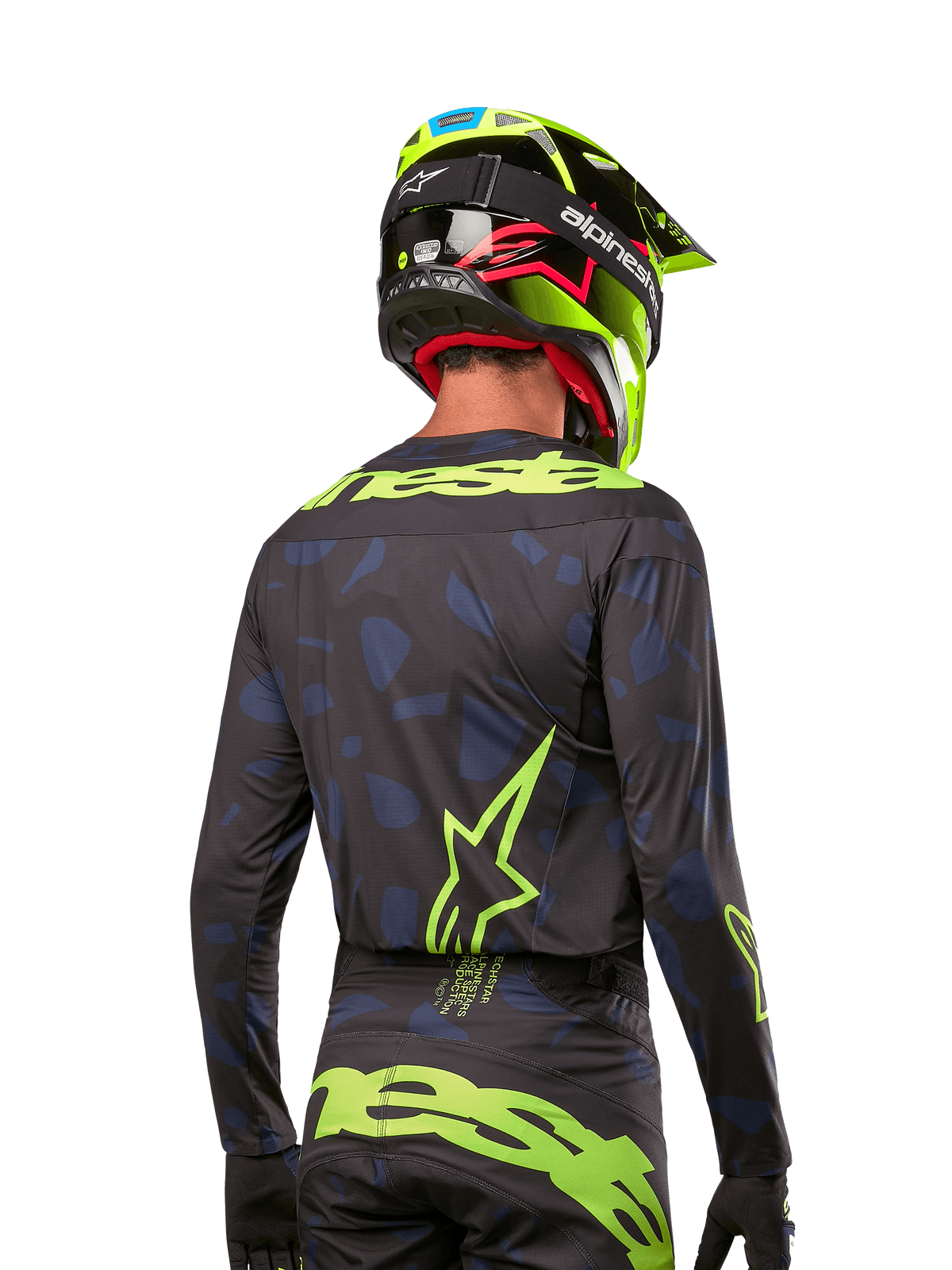 Rückansicht eines Motocross-Fahrers im Alpinestars 2024 Techstar Rantera Jersey in Schwarz Navy Gelb Fluo, mit auffälligem neongelbem Branding und Logos auf dem Rücken, kombiniert mit der passenden Motocross-Hose und einem neongelben Helm für einen kompletten Offroad-Racing-Look.