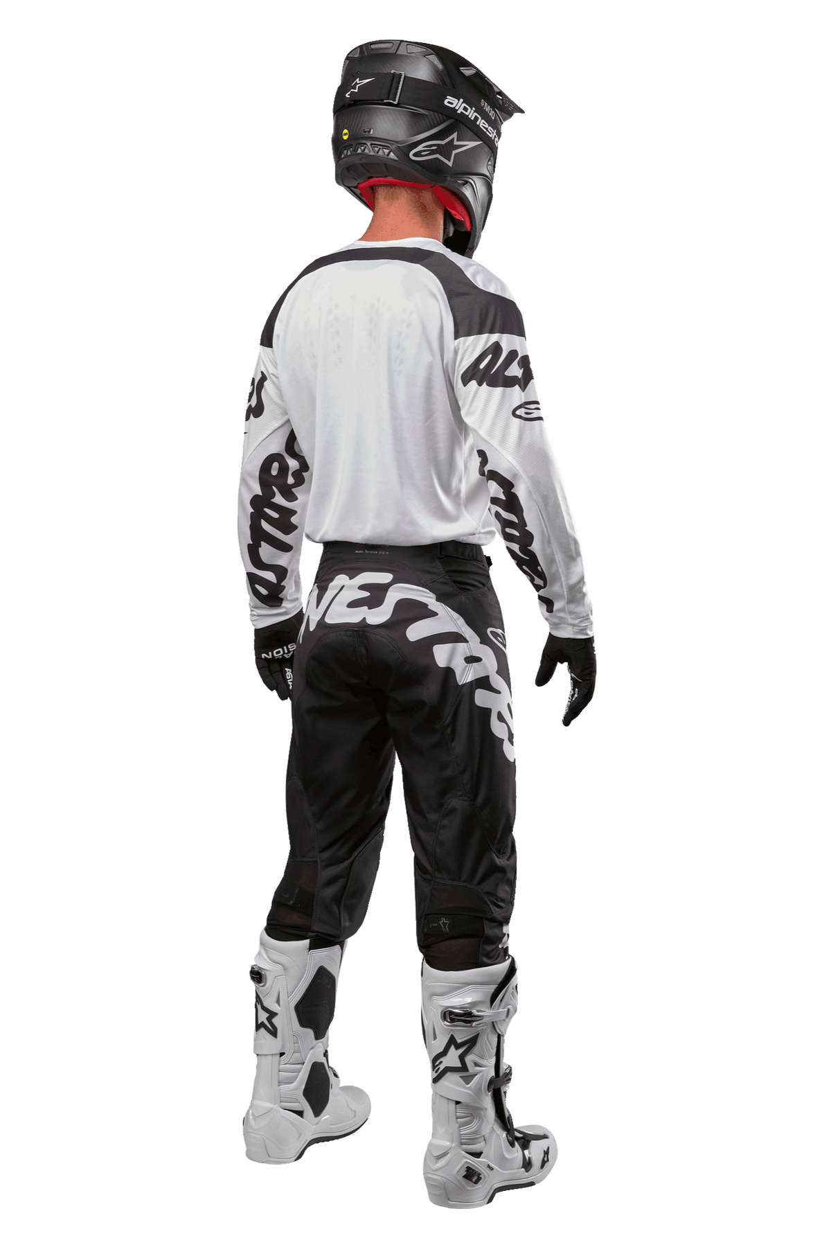 Alpinestars 2024 Racer Hana Trikot, Rückansicht eines Motocross-Fahrers, Weiß und Schwarz, weißes Trikot mit schwarzen Grafiken an den Ärmeln, kombiniert mit einer schwarzen Hose mit weißem Alpinestars-Schriftzug am Gesäß, schwarzer Helm und weiß-schwarze Stiefel, abgestimmte Offroad-Rennausrüstung
