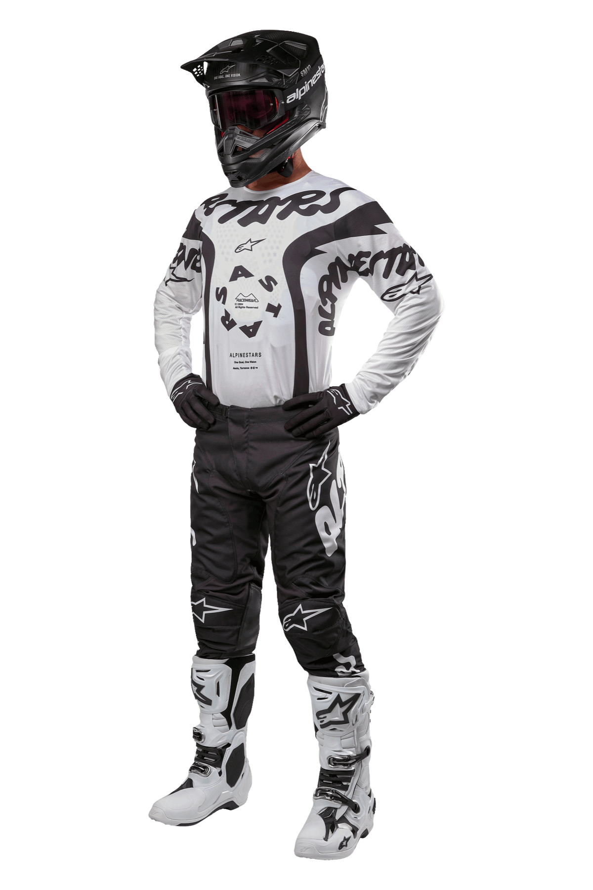 Motocross-Fahrer in kompletter Ausrüstung mit dem Alpinestars 2024 Racer Hana Jersey in Weiß und Schwarz, schwarze Motocross-Hose mit weißen Logos, schwarzer Helm, weiß-schwarze Racing-Stiefel und schwarze Handschuhe, professionelles Offroad-Rennoutfit