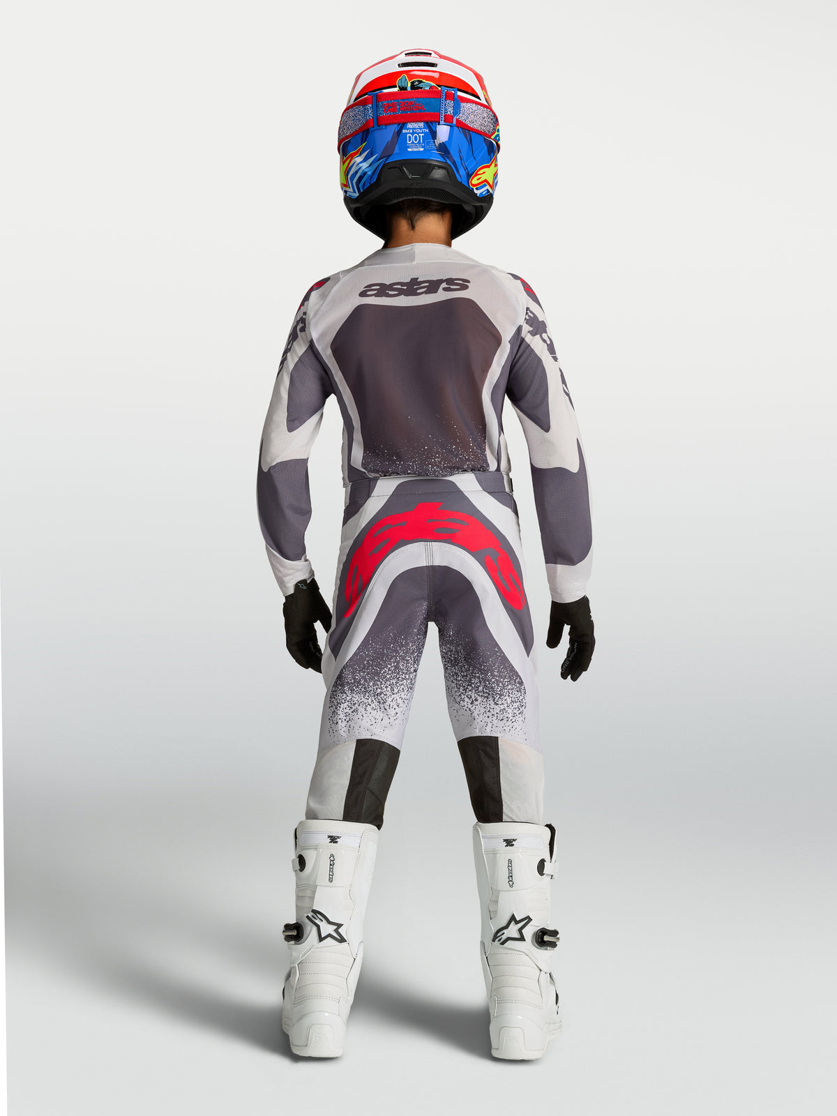 Alpinestars 2027 Jugend Supertech Swan Trikot und Gear-Set, grau-weiße Motocross-Kombi mit roten Akzenten, Rückansicht.