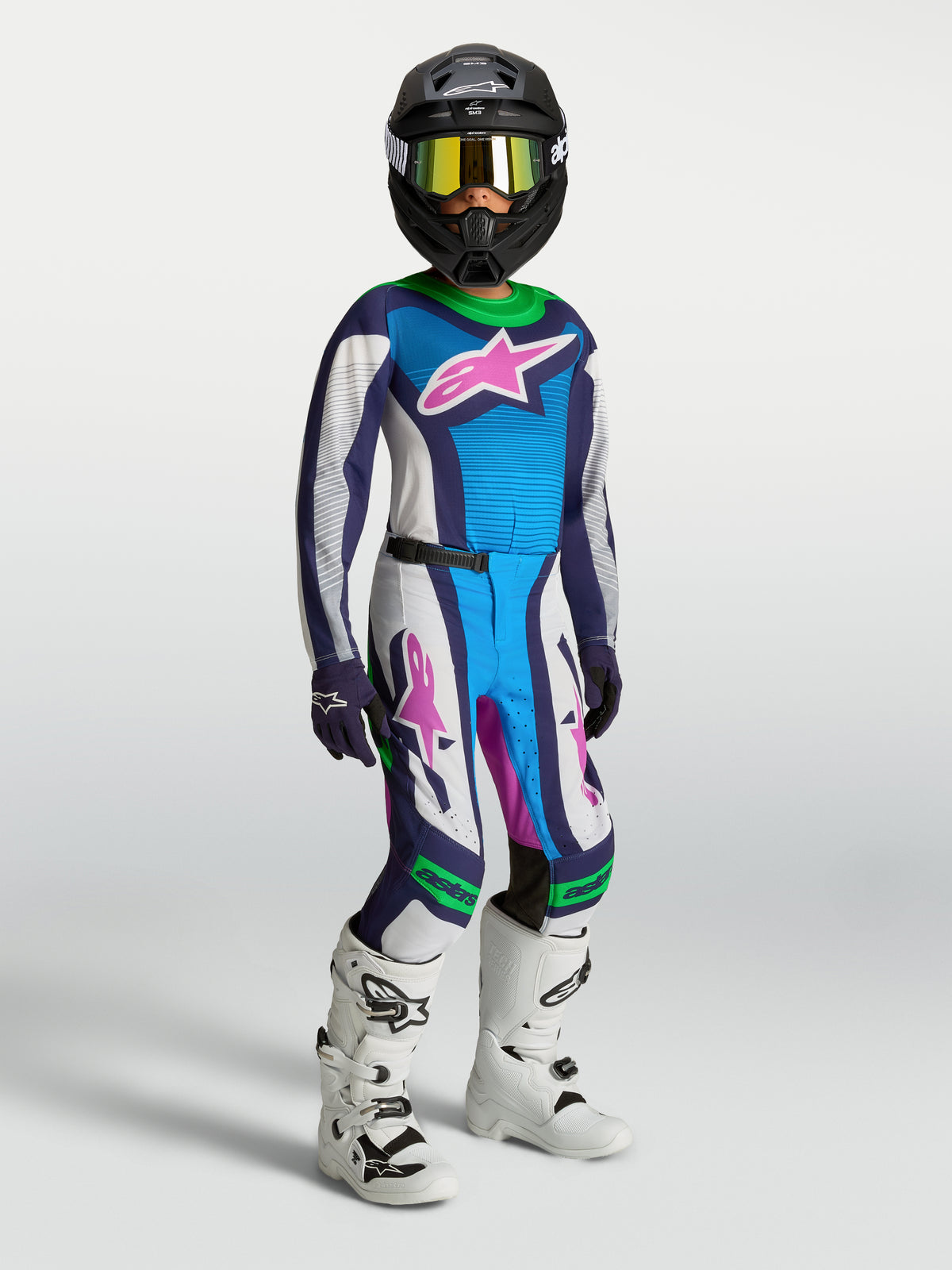Alpinestars Supertech Maven Jugend-Ausrüstungsset 2027, blau-weißes Motocross-Trikot, Hose mit grünen Akzenten und Stiefeln.