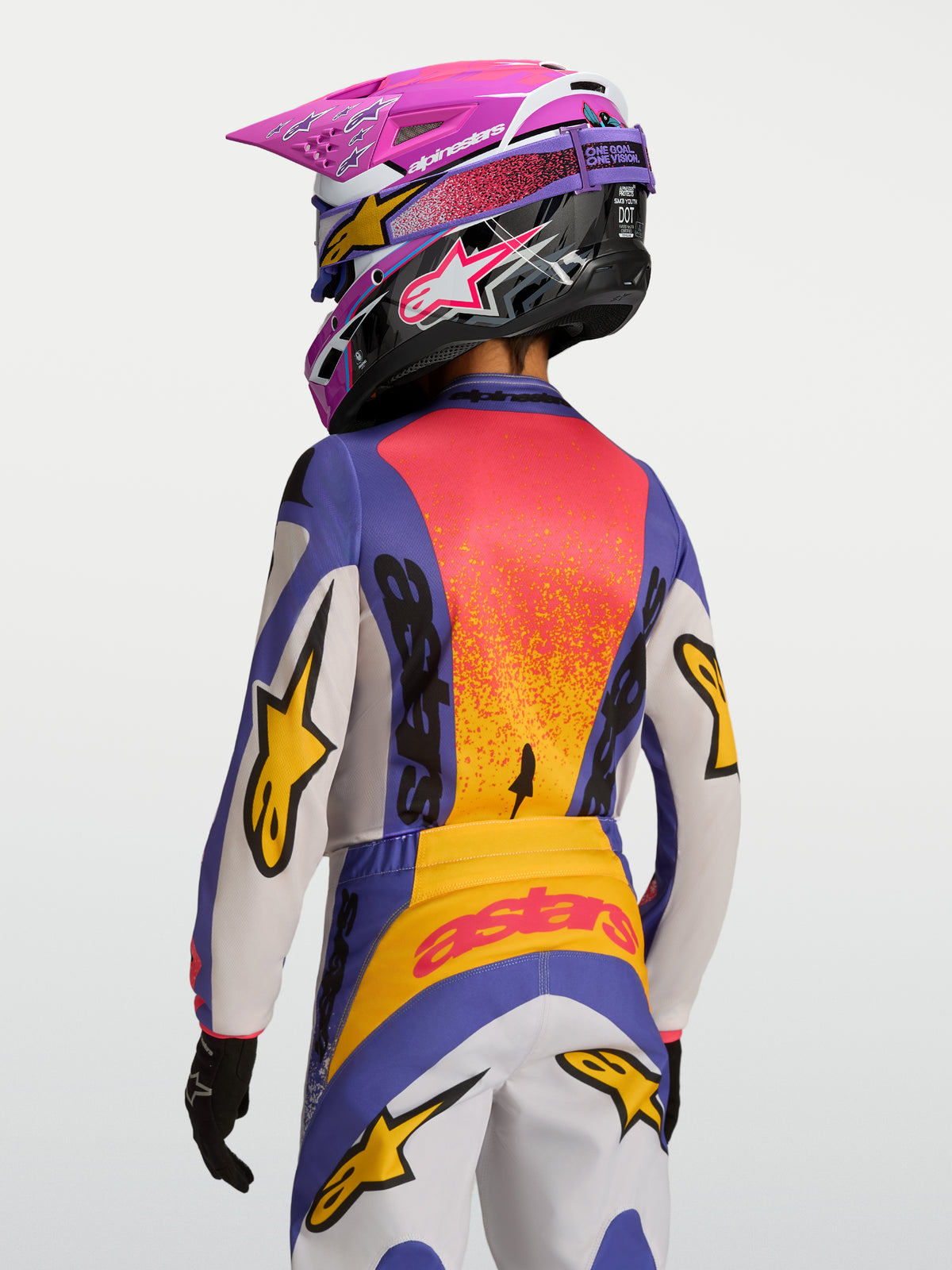 Alpinestars Fluid Jugend-Trikot Drag 2027, Motocross-Trikot in Lila und Orange, feuchtigkeitsableitend, Rückansicht mit Helm.