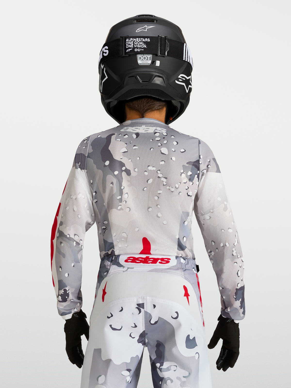 Alpinestars 2027 Youth Fluid Lone Jersey, gray camo motocross top, rear view with red accents and black helmet.