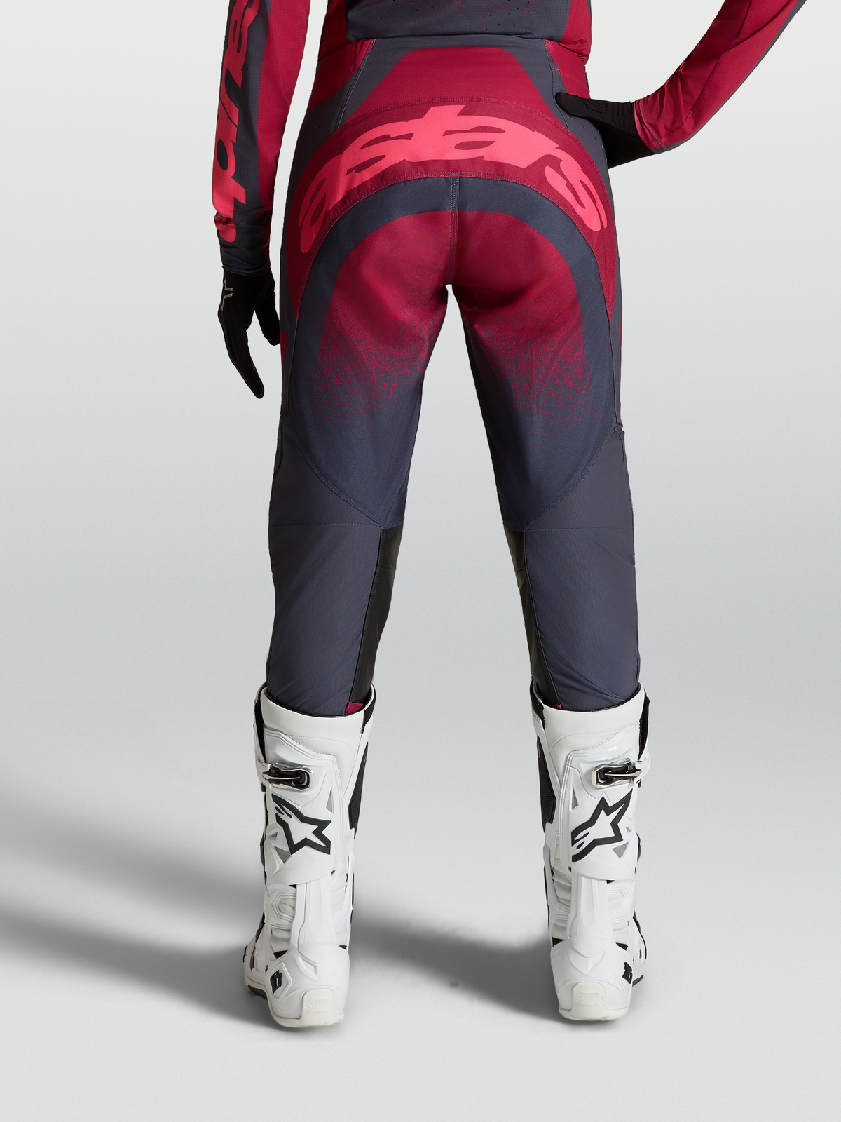 Alpinestars Stella Techstar Swan Hose, Damen-Motocross-Ausrüstung, Rot und Grau, Rückansicht mit weißen Rennstiefeln