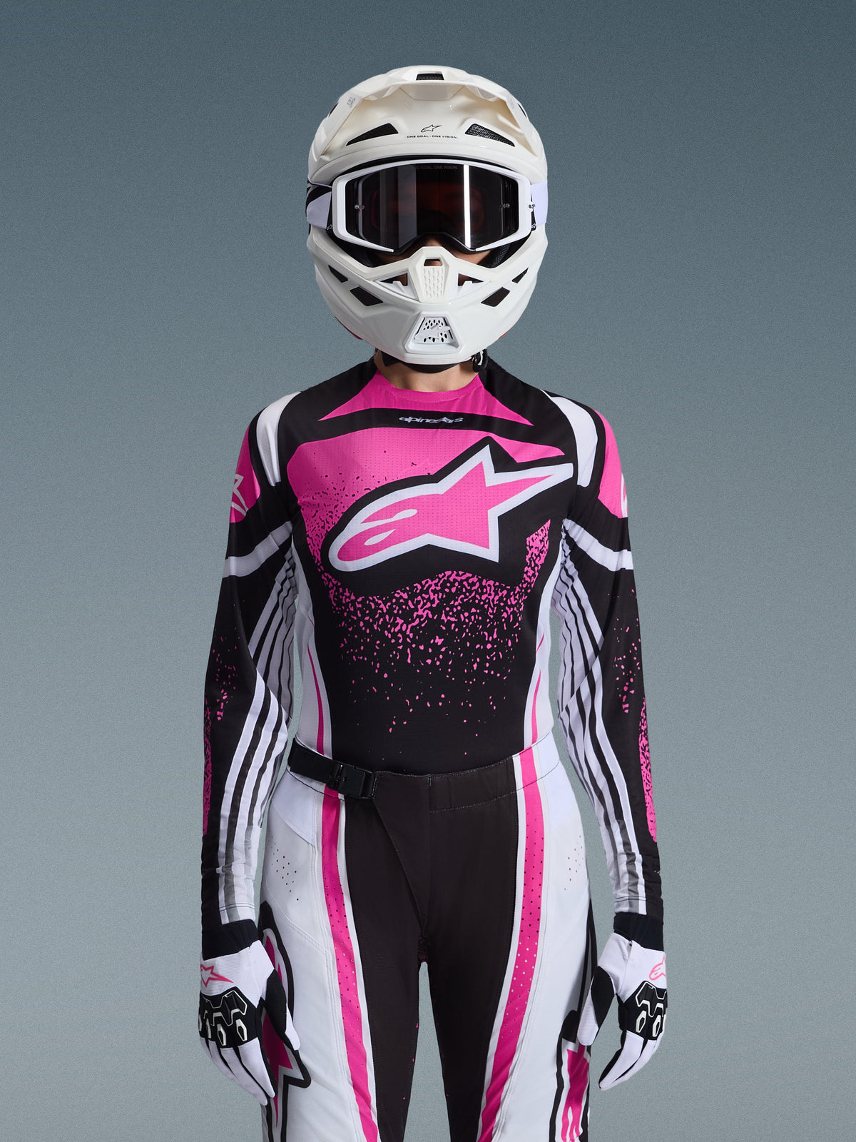 Alpinestars 2026 Stella Techstar Nomur Gear Set, Women's Motocross Outfit, Pink Black and White with large star logo, featuring matching jersey, pants, and gloves with a white helmet, front view on a grey background