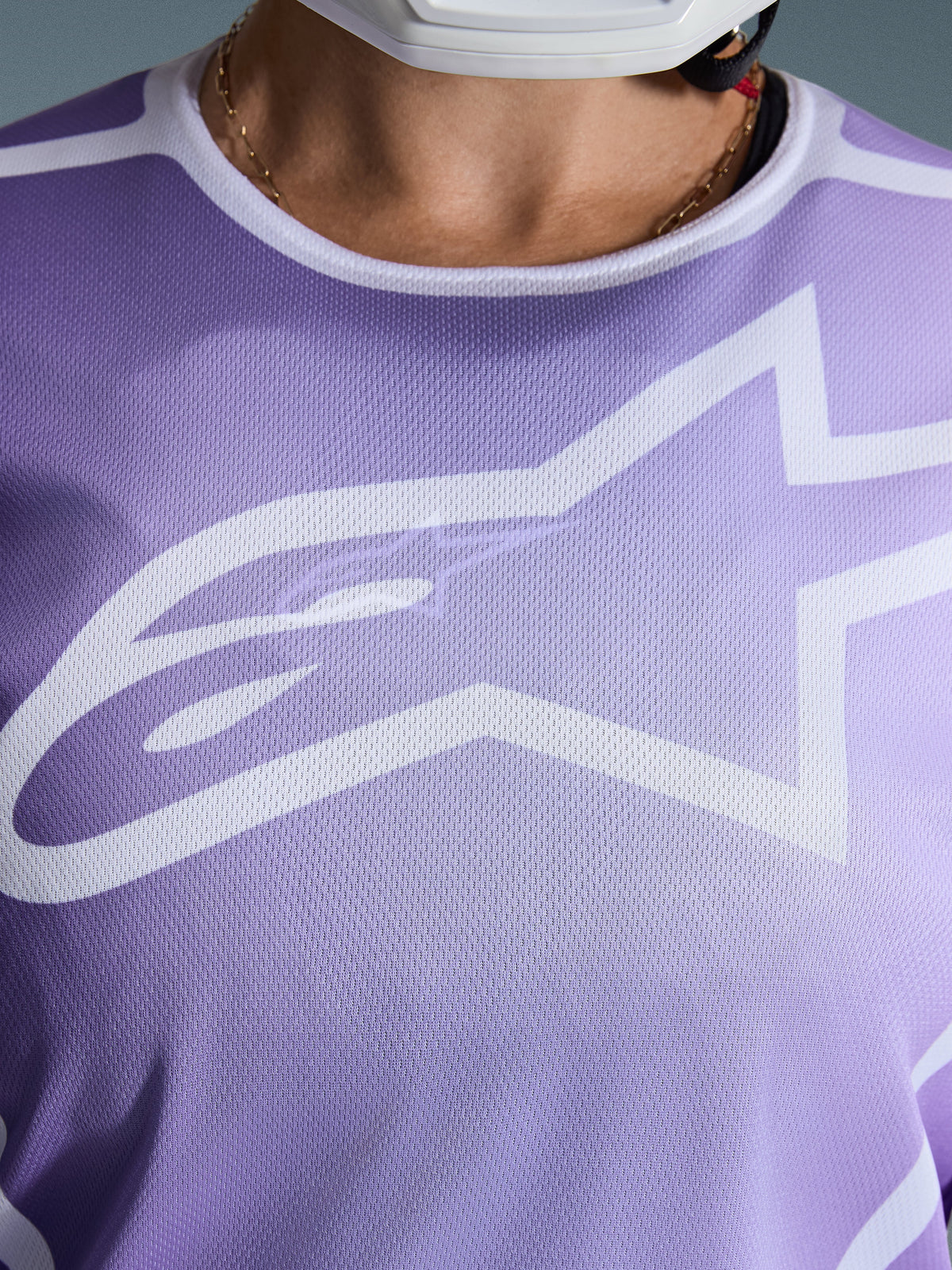 Alpinestars 2026 Stella Fluid Apex Jersey, Close-up of chest, Purple with white graphics, featuring a large white Astars logo on mesh polyfabric construction.