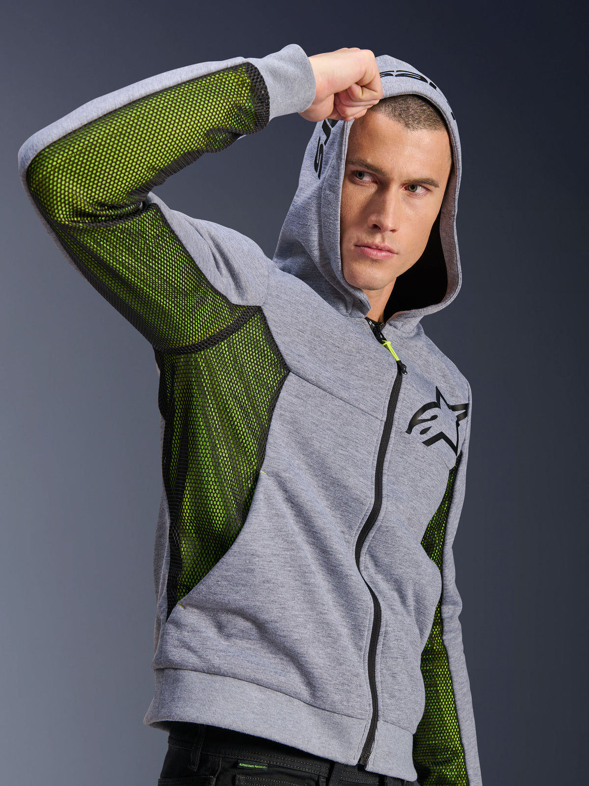 Alpinestars Chrome Air Sport Hoodie, Grau Meliert und Schwarz, mit leuchtend grünen Mesh-Einsätzen für Luftzirkulation an den Seiten und unter den Ärmeln, Tech-Fleece-Material mit Kapuze, schwarzes Alpinestars-Logo auf der Brust, urbane Motorradbekleidung