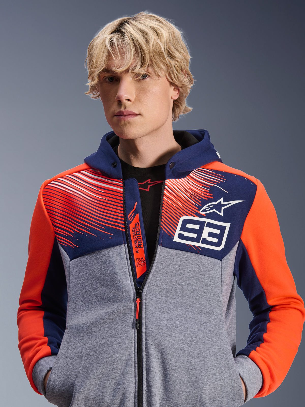 Alpinestars MM93 Chrome V2 Sport Hoodie, urbaner Motorrad-Hoodie, Dunkelblau und Grau Melange mit Red Fluo Akzenten, mit Marc Marquez 93 Branding und Alpinestars Logo, Design mit durchgehendem Reißverschluss, lässige Lifestyle-Bekleidung für Fahrer