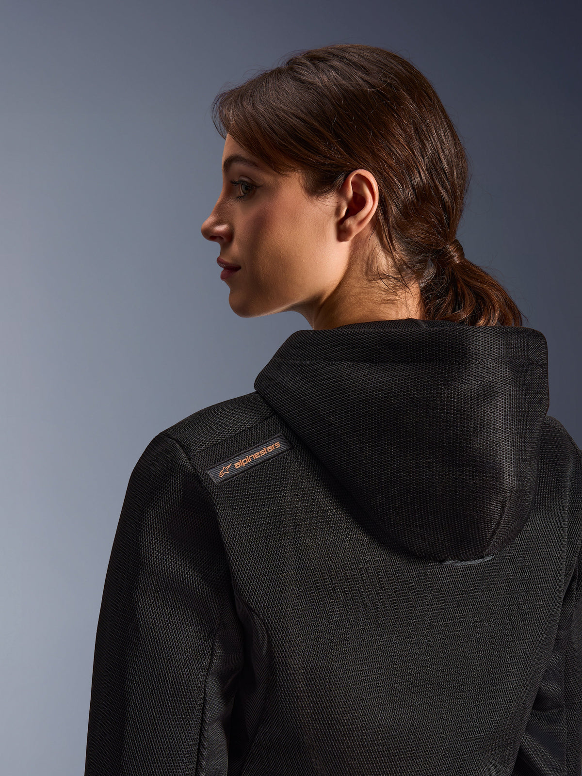 Alpinestars Stella Chrome Superairflow Hoodie, Motorrad-Kapuzenpullover für Damen, Schwarz mit kupferfarbenem Logo-Detail, Nahaufnahme der 3D-Mesh-Konstruktion an Rücken und Schulter, technische Schutzausrüstung für urbanes sportliches Fahren