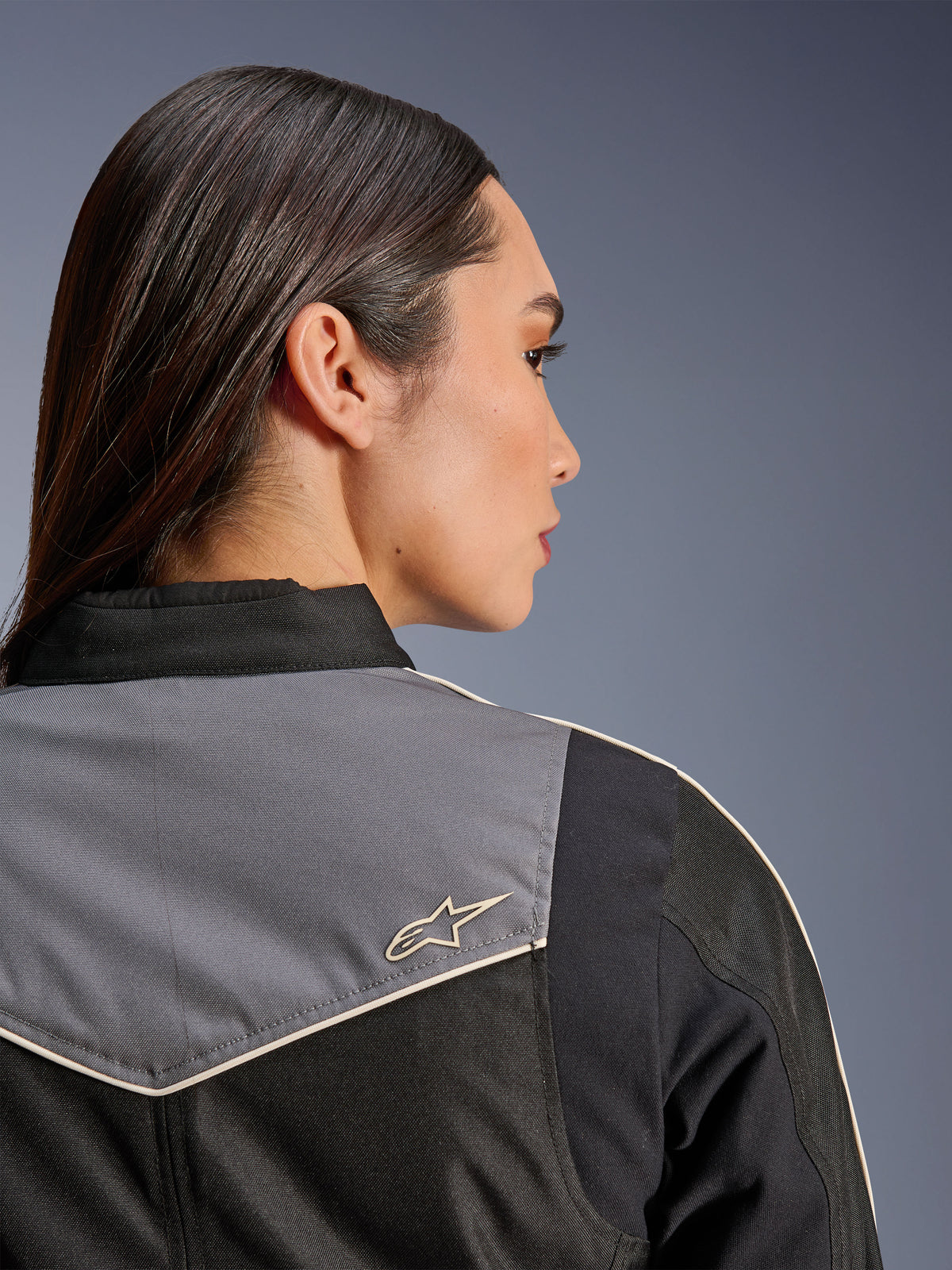 Alpinestars Stella T-Dyno WR Jacke, Damen-Motorradjacke, Schwarz, Dunkelgrau und Ecru, Nahaufnahme der Rückansicht von Schulter und Passe mit grauem Einsatz und ecrufarbenem Stern-Logo, Vintage-inspirierte Motorradausrüstung