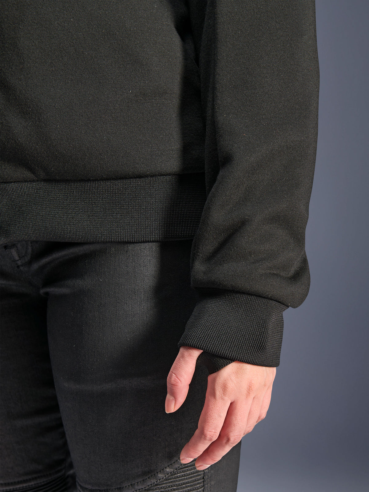 Alpinestars Stella Chrome V2 Sport Hoodie, Schwarz, Nahaufnahme des gerippten Ärmelbündchens mit Daumenloch und des gerippten Taillensaums, Tech-Fleece-Material für urbanes Motorradfahren