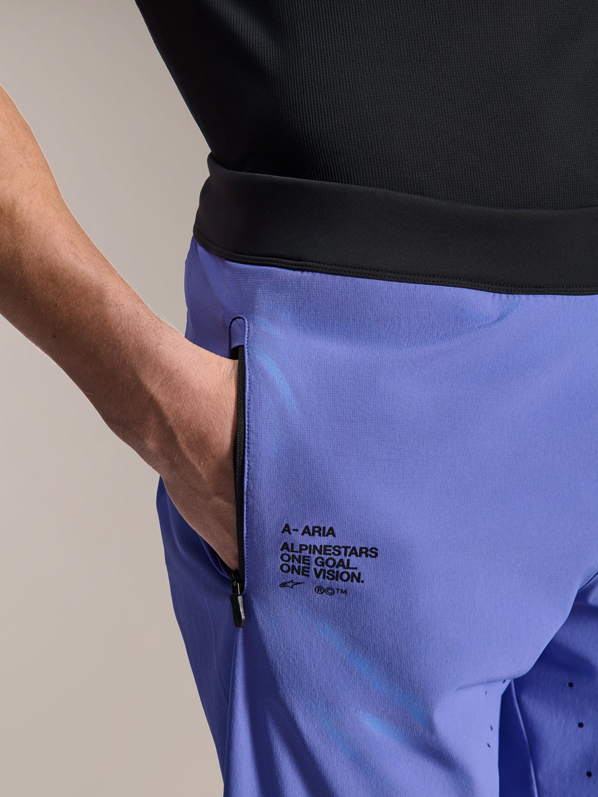 Alpinestars A-Aria Lite Short, MTB-Shorts, Baja Blue, Nahaufnahme mit vorderer Reißverschlusstasche und seitlichem Branding mit „One Goal. One Vision.“-Schriftzug, schwarzer Bund, technisches Material für Mountainbiking