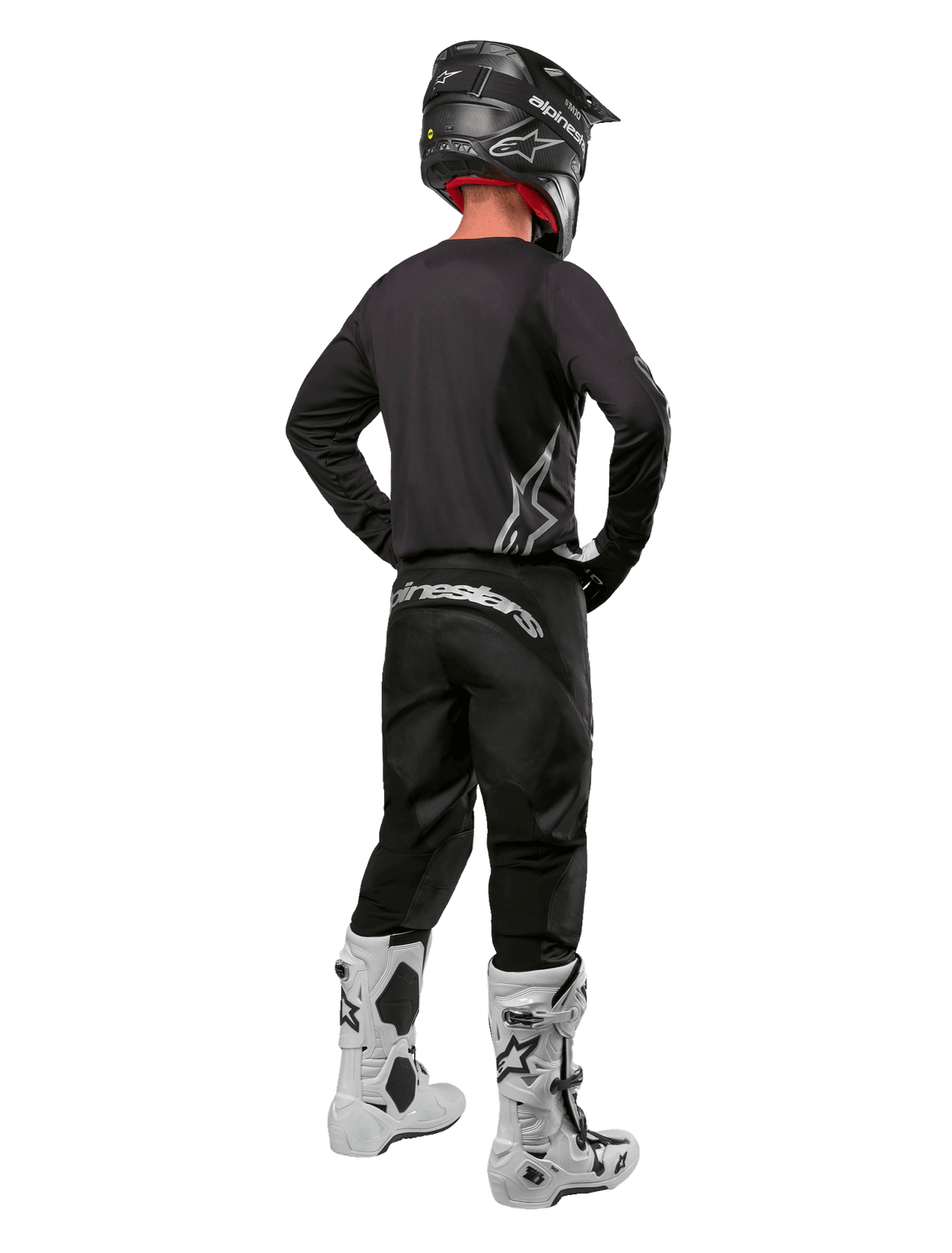 Alpinestars 2024 Fluid Graphite Gear Set, Motocross-Fahrer in der Rückansicht, graphitgraues Jersey und Hose mit silbernem Alpinestars-Branding, schwarzer Helm und weiße Motocross-Stiefel, athletische Passform für den Offroad-Einsatz
