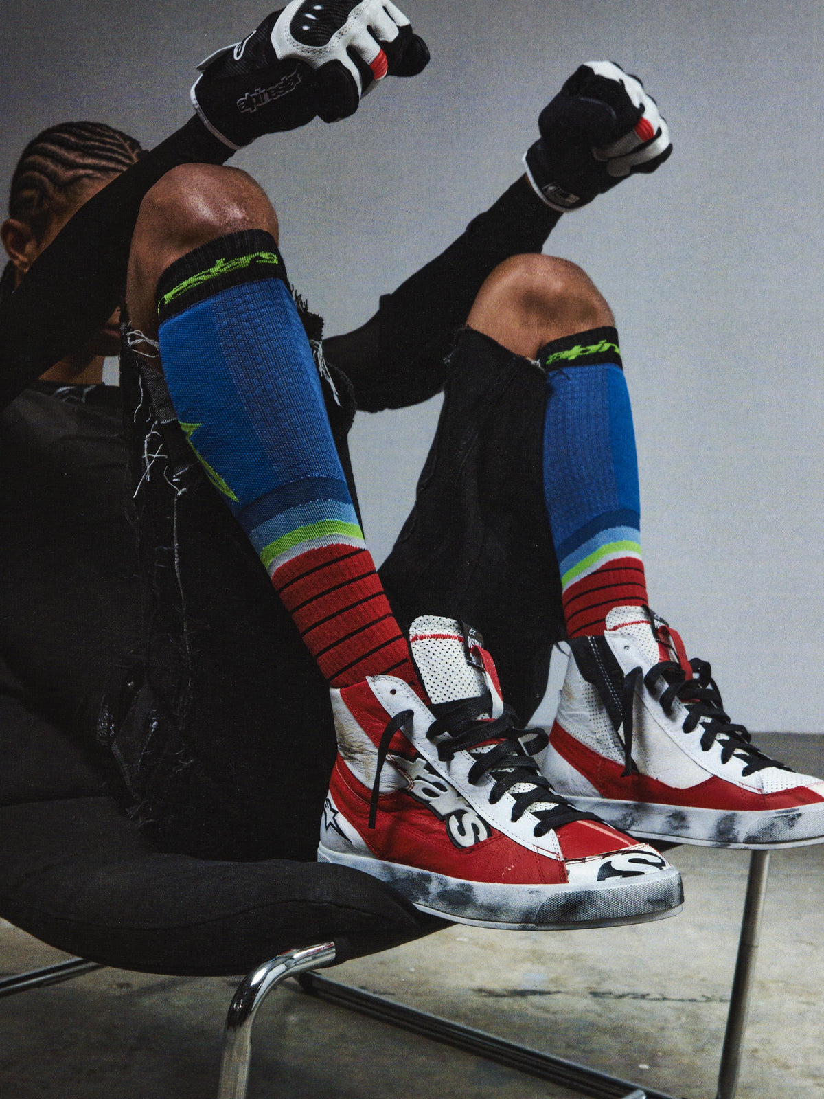 Alpinestars RSRV Legacy Shoe, Lifestyle-Sneaker, Rot und Weiß mit Schwarzen Akzenten, Premium-Konstruktion, Person trägt bunte Kniestrümpfe und schwarze Handschuhe