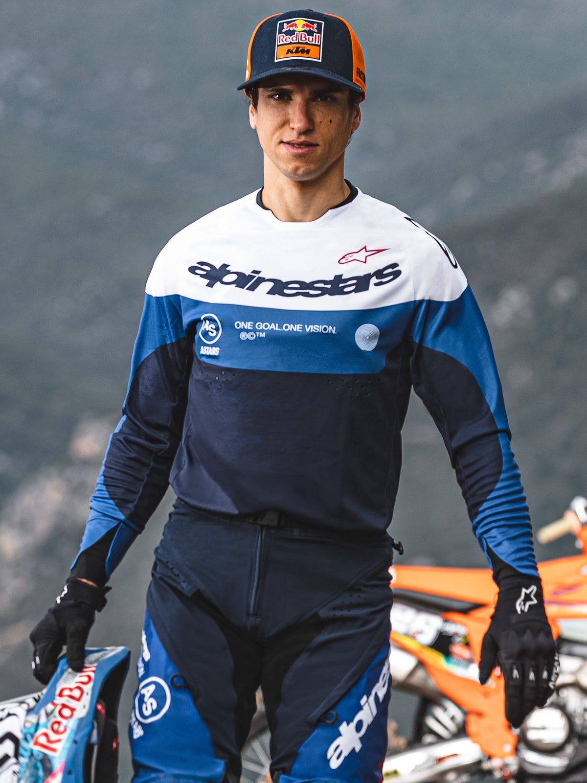 Motocross-Fahrer im Alpinestars Pro-Dura Jersey in Navy, Hellblau und Weiß, mit Alpinestars-Schriftzug und „One Goal. One Vision.“ Slogan, passende Motocross-Ausrüstung, Red Bull KTM Cap, Outdoor-Umgebung