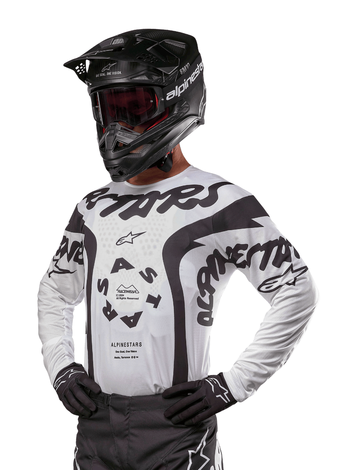 Alpinestars 2024 Racer Hana Trikot, Motocross-Renntrikot, Weiß und Schwarz, markante Grafiken mit Alpinestars- und Astars-Branding, getragen mit schwarzem Helm und schwarzen Handschuhen, Performance-Offroad-MX-Ausrüstung
