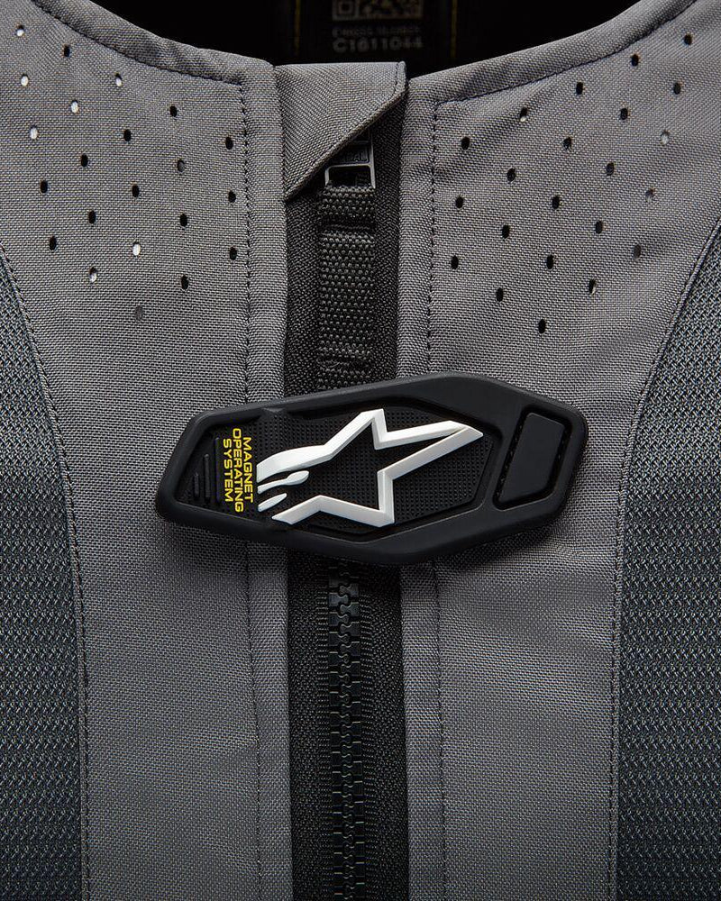 Alpinestars Tech-Air 5 System detail, magnetic operating flap with white star logo on gray perforated fabric.