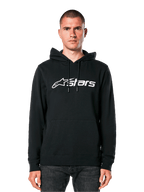 Alpinestars Blaze V3 Hoodie, schwarzer Kapuzenpullover mit weißem Logo, lässige Streetwear, mit Kängurutasche vorne und Kapuze mit Kordelzug, von einem Mann getragen, modernes motorsport-inspiriertes Design
