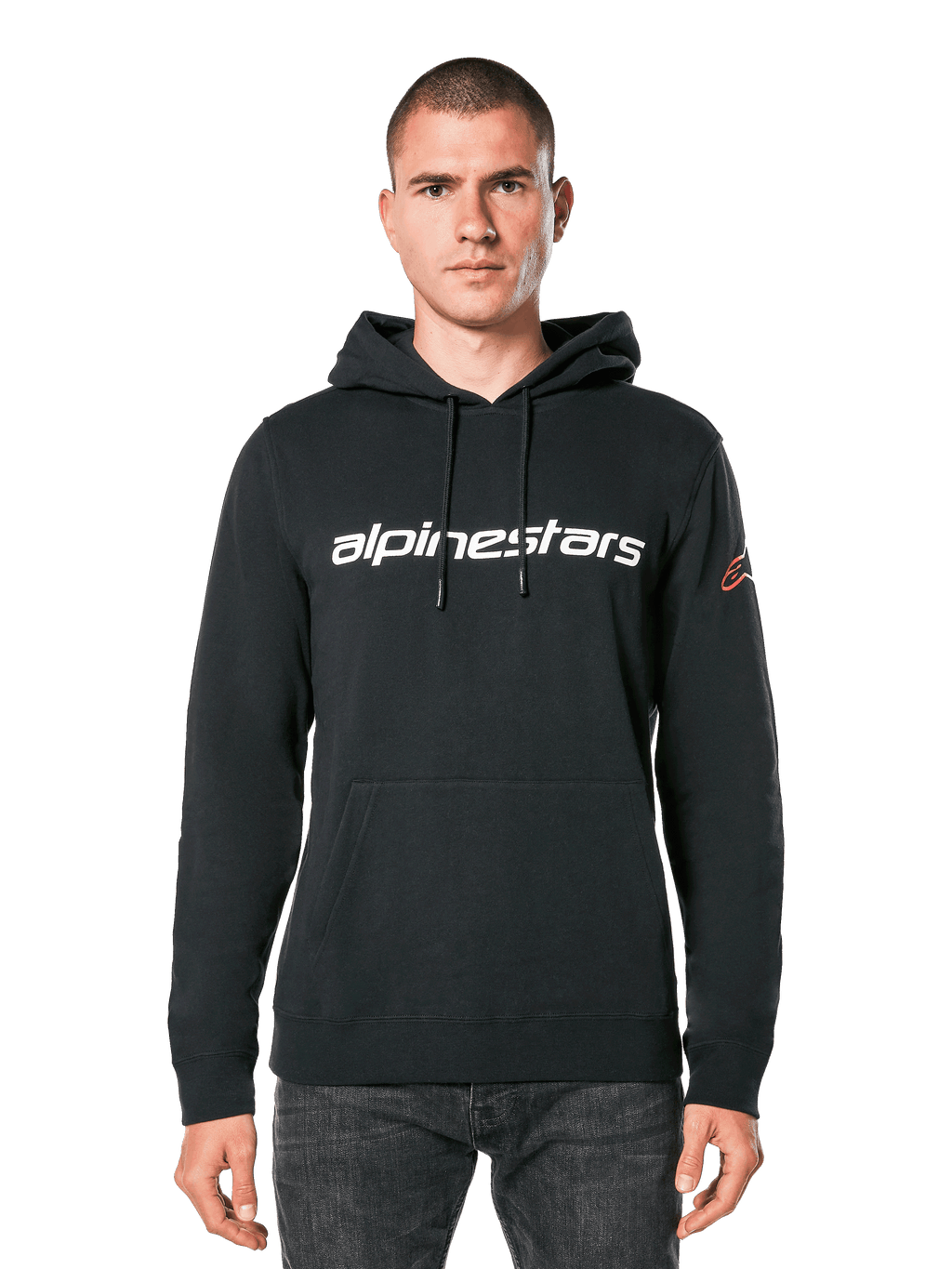 Alpinestars Linear Wordmark V3 Hoodie, schwarzer Kapuzenpullover, weißer Alpinestars-Schriftzug auf der Brust, rotes Ageless-Logo am Ärmel, Kängurutasche vorne, Kapuze mit Kordelzug, getragen von einem männlichen Model, lässige, vom Motorsport inspirierte Streetwear