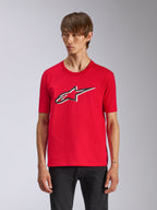 Alpinestars Ageless Shadow CSF Tee, rotes Kurzarm-T-Shirt, mit vorderseitigem Ageless-Logo mit schwarz-weißen Konturen, getragen von einem Mann mit schwarzer Hose, lässige Motorsport-Streetwear