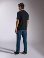 Alpinestars Ageless Shadow CSF T-Shirt, Kurzarm-T-Shirt, Schwarz, Rückansicht, kombiniert mit blauen Jeans und schwarzen Sneakern, lässige, vom Motorsport inspirierte Streetwear