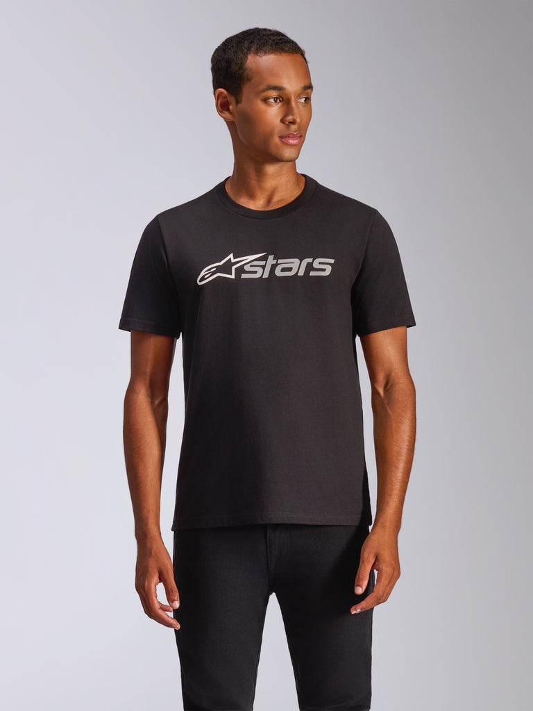 Alpinestars Blaze 2.0 CSF Tee, schwarzes Kurzarm-T-Shirt getragen von einem Model, grau-weißes Alpinestars-Logo auf der Brust, lässige Motorsport-inspirierte Streetwear