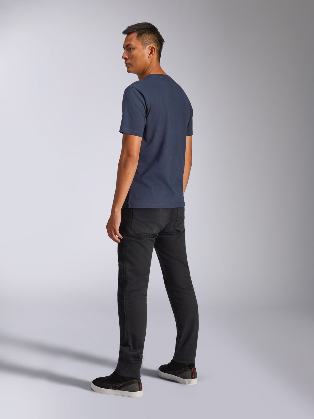 Alpinestars Blaze 2.0 CSF Tee, kurzärmeliges T-Shirt, Marineblau, Rückansicht am Modell, kombiniert mit schwarzer Hose und Sneakern, lässige Motorsport-inspirierte Streetwear