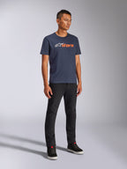 Alpinestars Blaze 2.0 CSF Tee, Kurzarm-T-Shirt, Navyblau mit weißem und orangefarbenem Blaze-Logo, getragen von einem Model mit schwarzer Hose und Sneakern, lässige, vom Motorsport inspirierte Streetwear