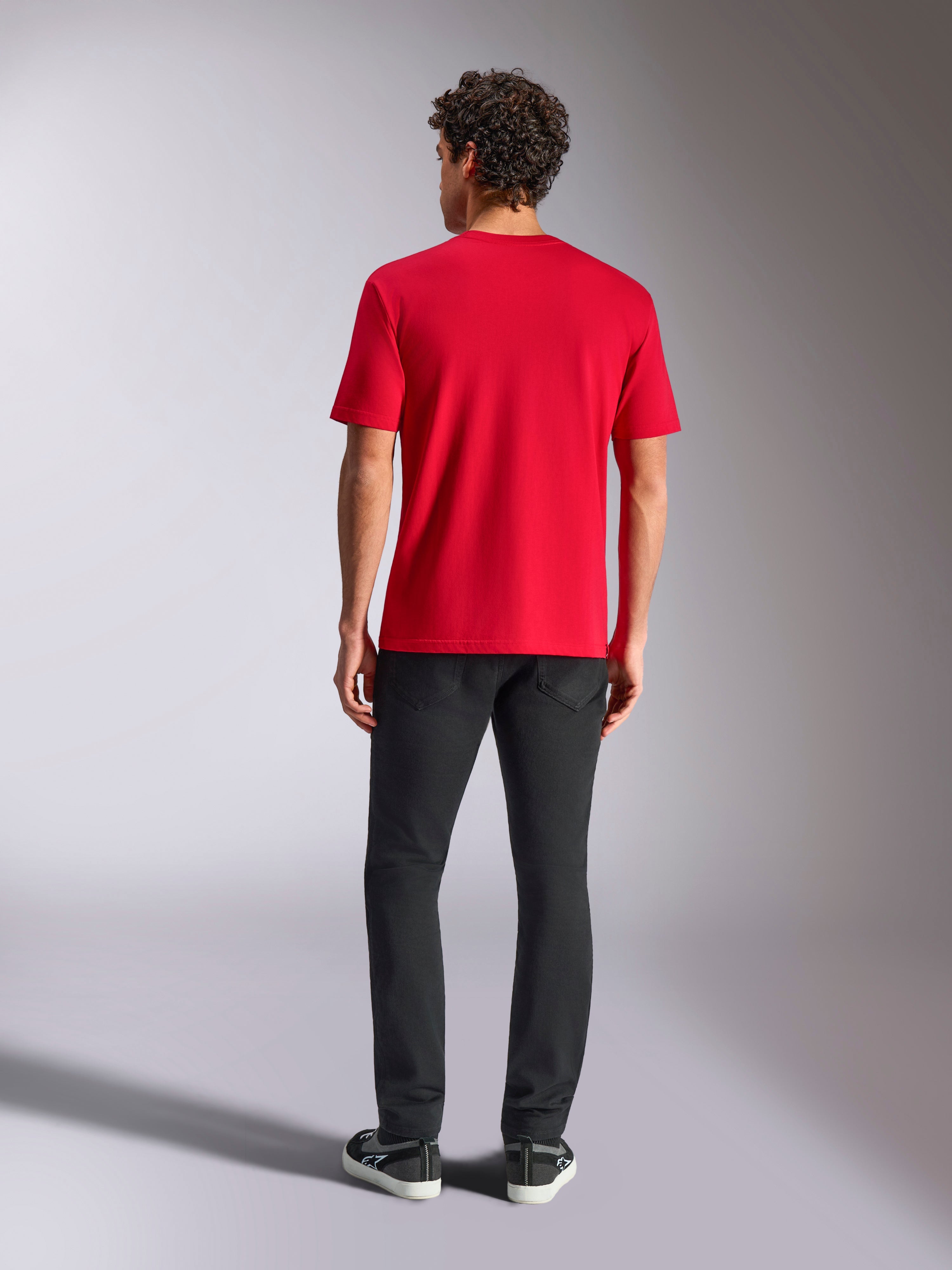 Alpinestars Ride 4.0 CSF Tee, Kurzarm-T-Shirt, Rot, Rückansicht, kombiniert mit schwarzer Hose und schwarzen Sneakern, lässige Motorsport-Streetwear