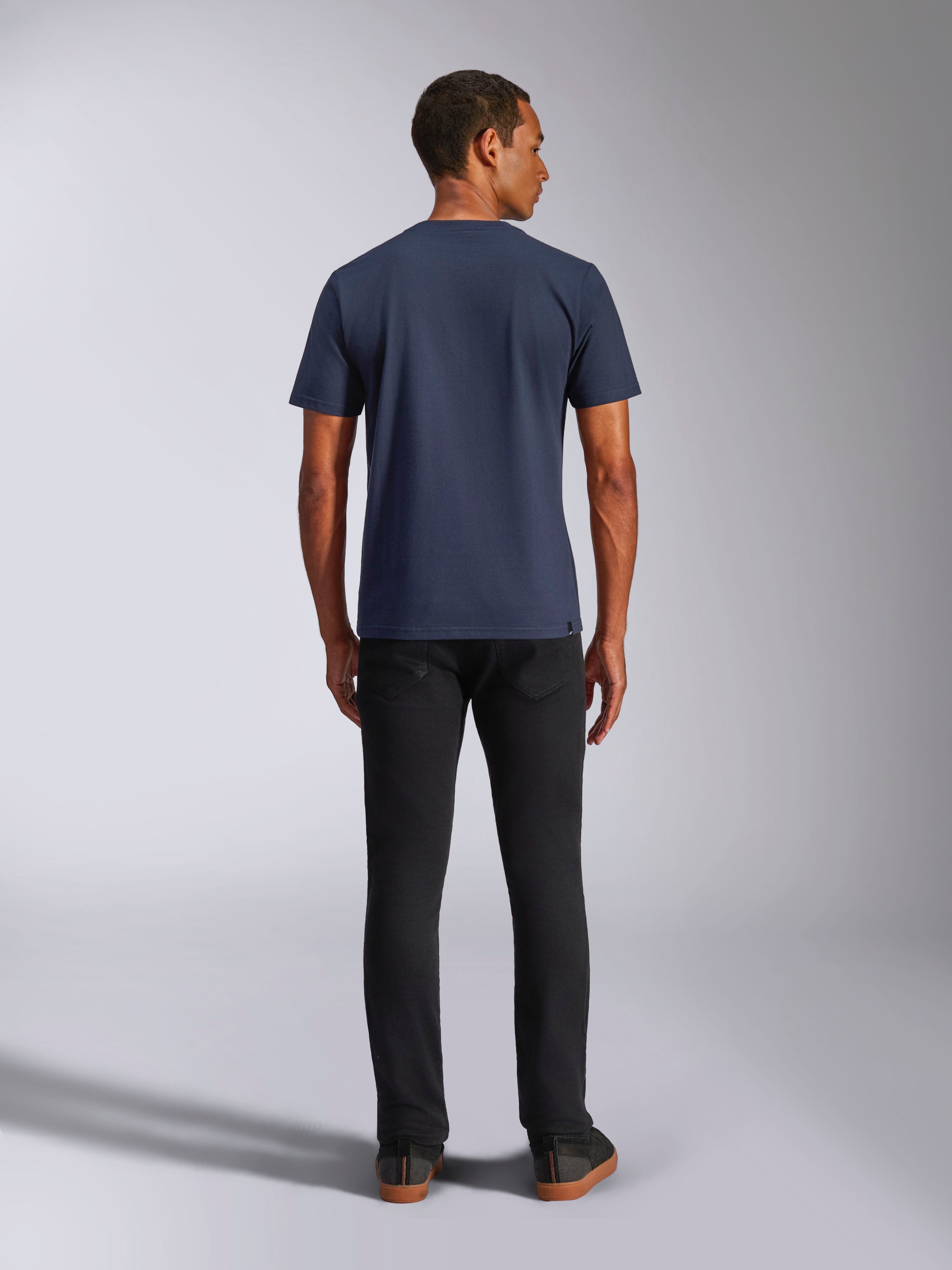 Alpinestars Ride 4.0 CSF Tee, kurzärmeliges T-Shirt, Marineblau, Rückansicht am Modell, kombiniert mit schwarzer Jeans, lässige, vom Motorsport inspirierte Streetwear