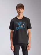 Alpinestars CSF Tee, kurzärmeliges T-Shirt, Schwarz, blaue Motocross-Helm-Grafik mit weißem Astars-Logo, lässige, vom Motorsport inspirierte Streetwear, getragen von einem Model